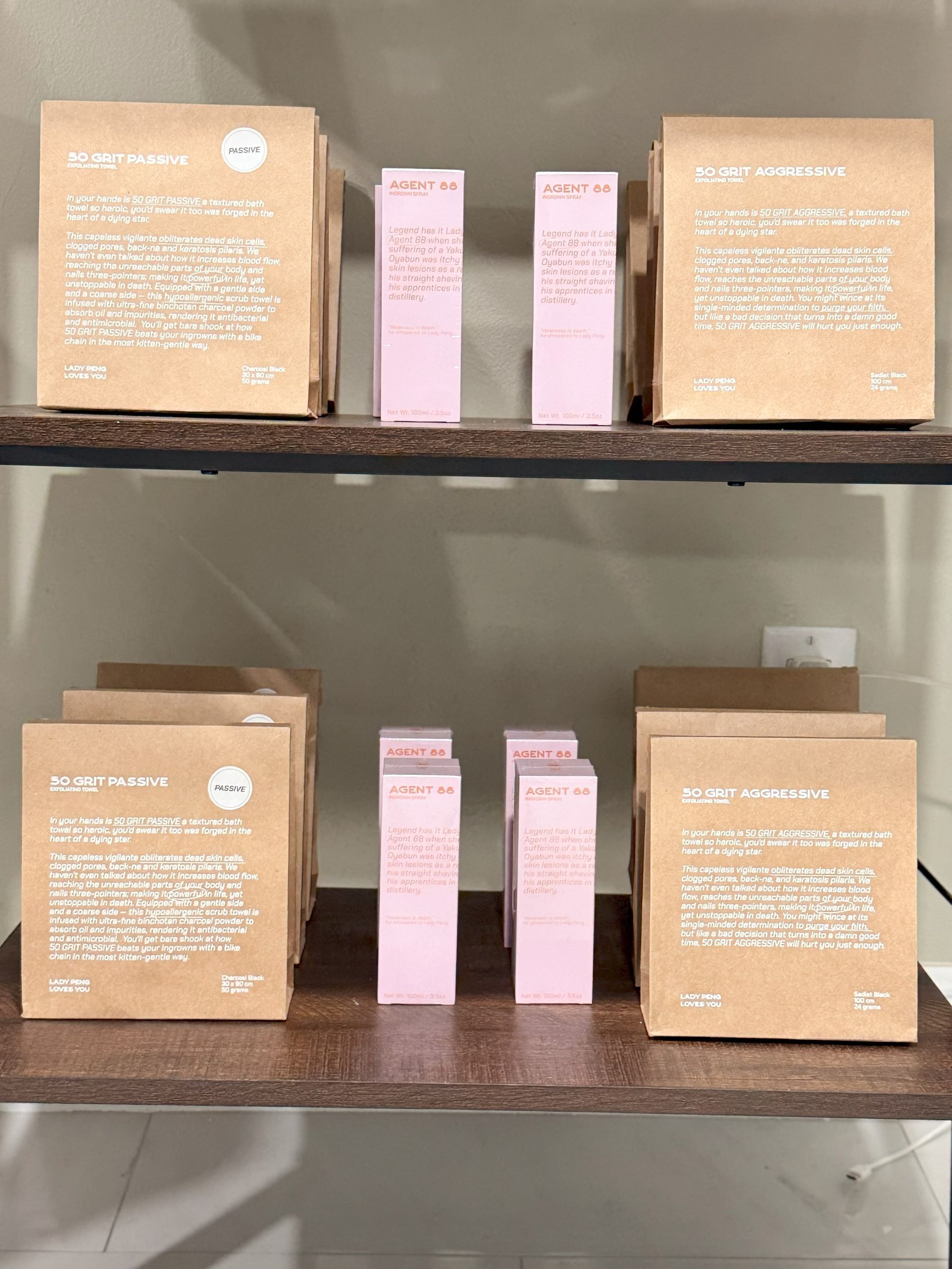 Two shelves of beauty products: boxes and pink bottles on a wooden shelf.