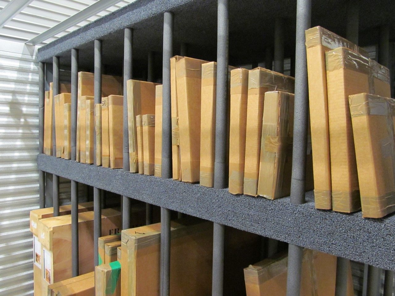 image of large, nondescript cardboard boxes on orange, metal shelving