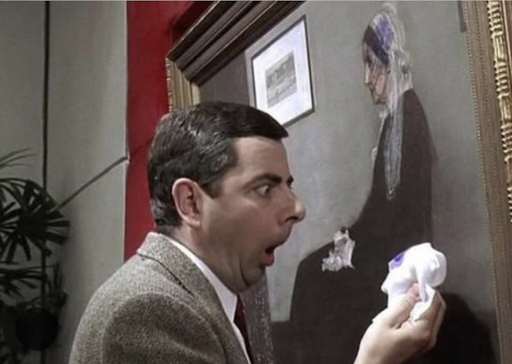 Mr. Bean still of him rubbing ink on a painting with a look of shock and horror on his face