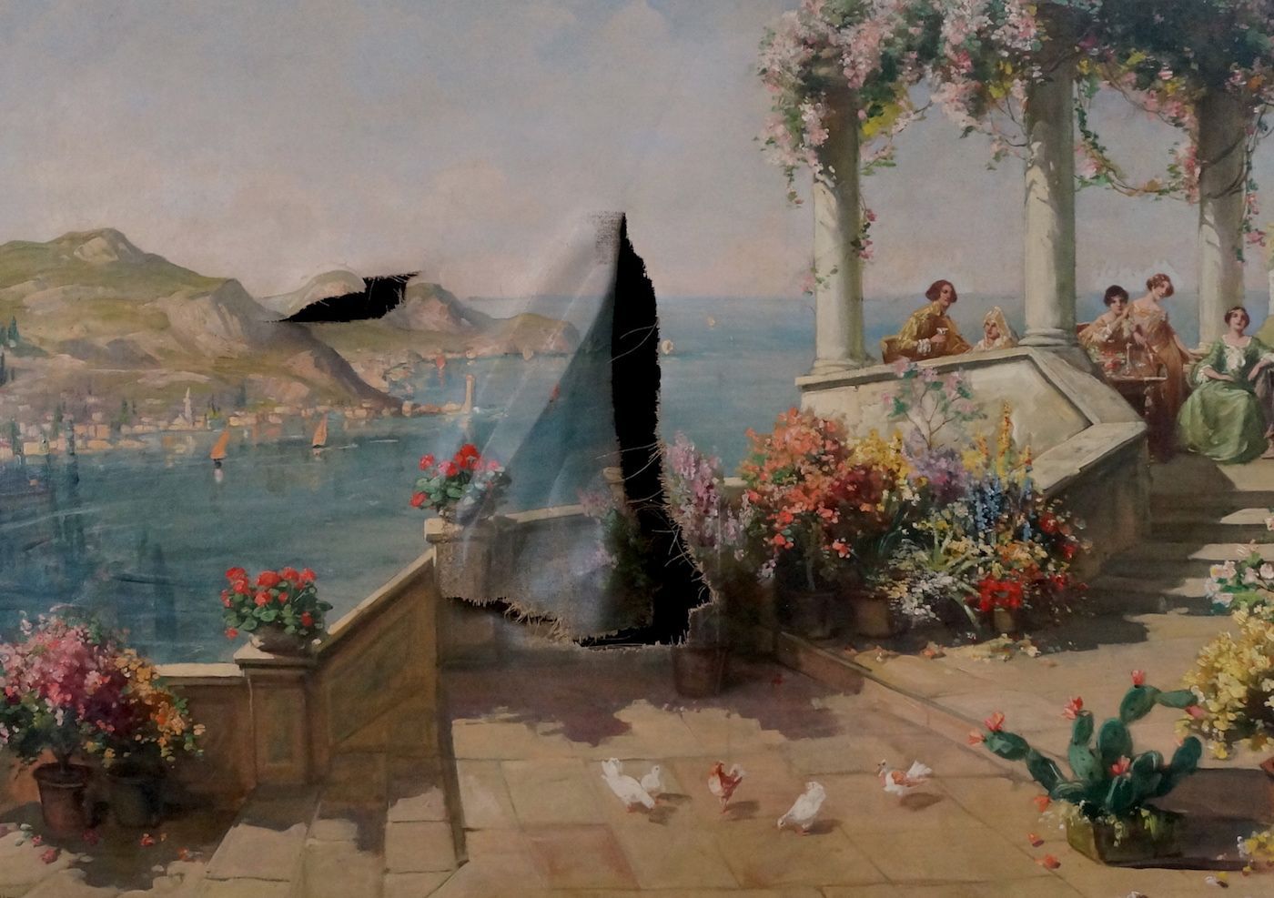 A Mediterranean landscape painting with one large L-shaped tear in the center and a smaller, horizontal tear to the left