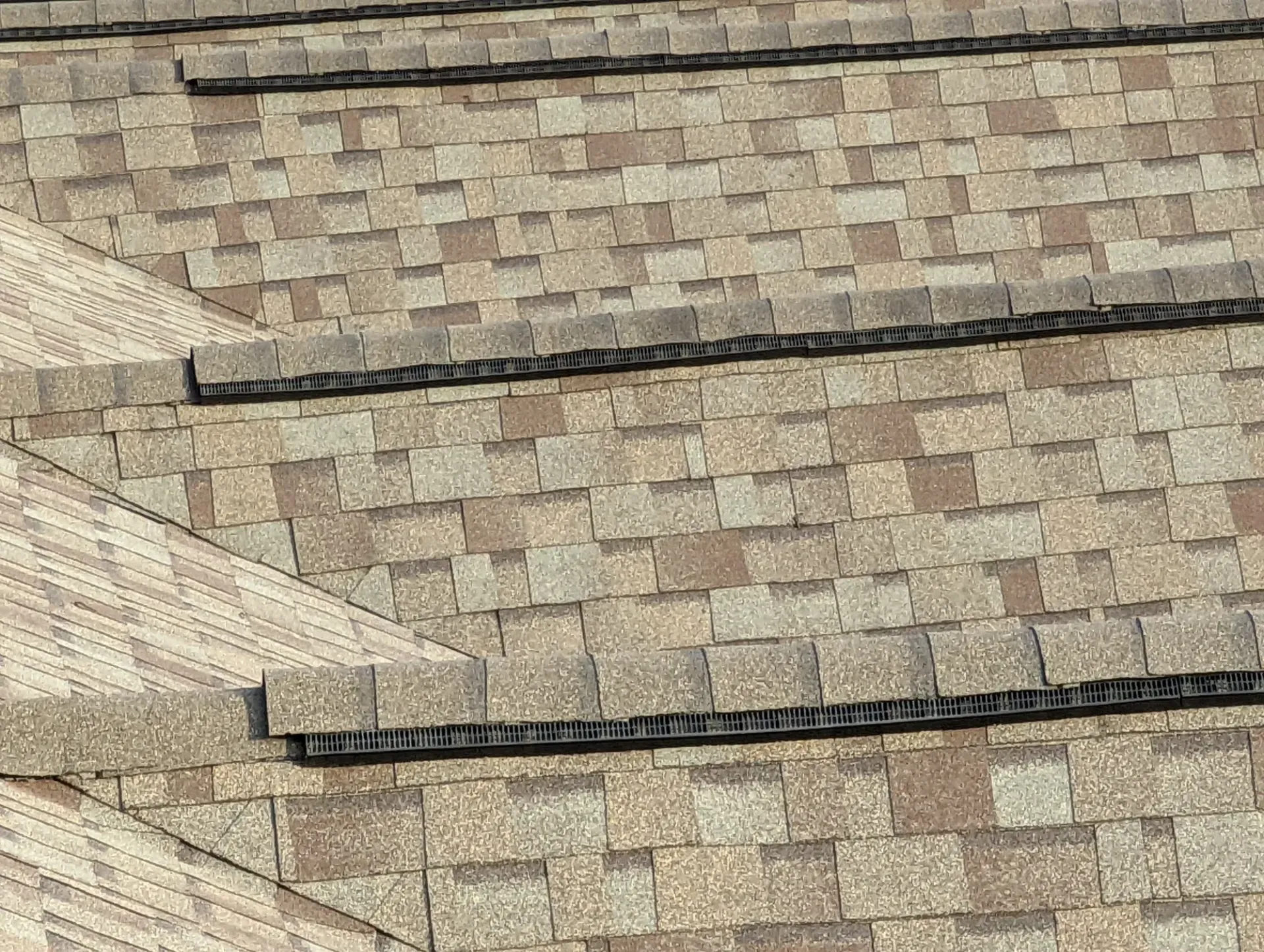 Close-up of a brown shingle roof with visible seams.