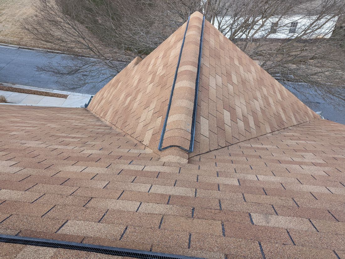 Brown shingle roof with a central ridge, view from above.