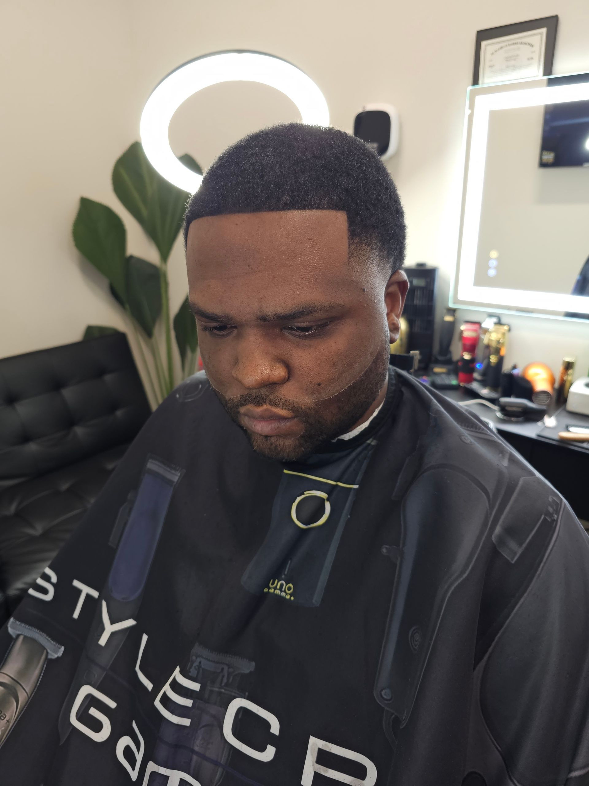 A man is getting his hair cut at a barber shop.