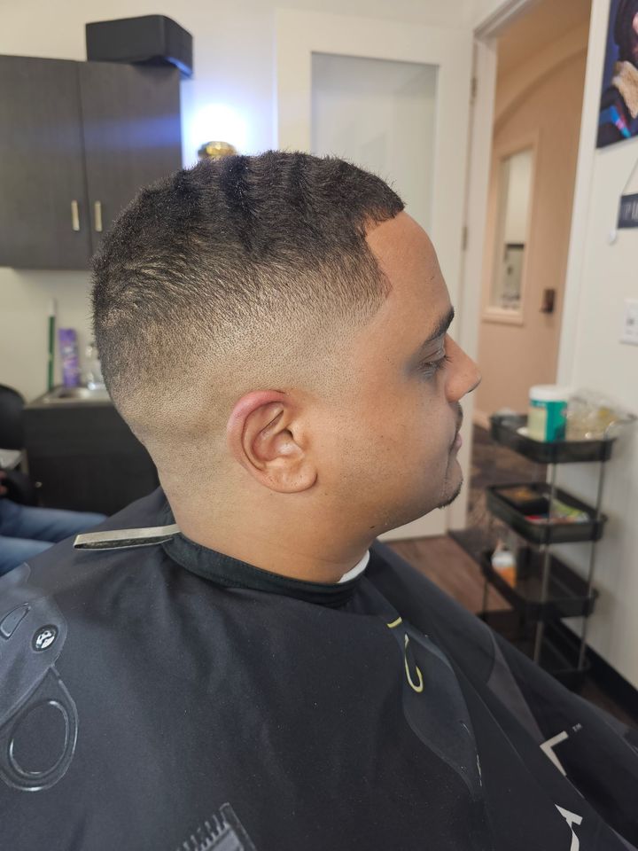 A man is getting his hair cut at a barber shop