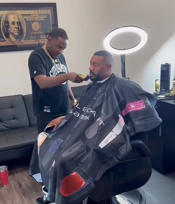 A man is getting his hair cut at a barber shop