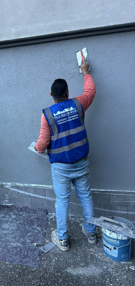 Interno di un cantiere edile, con scala in legno, attrezzi e materiali.