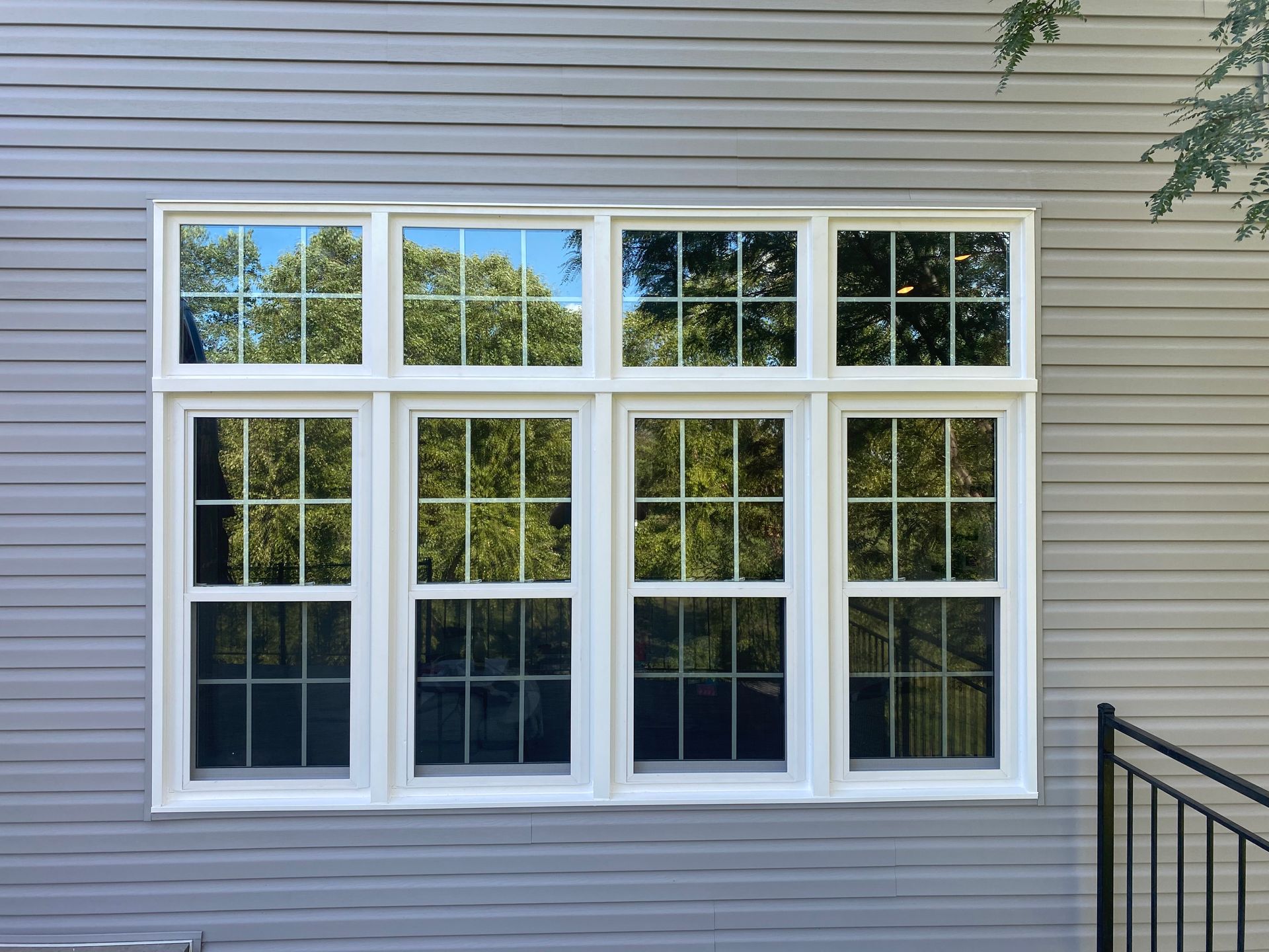 There are three windows on the side of a house.