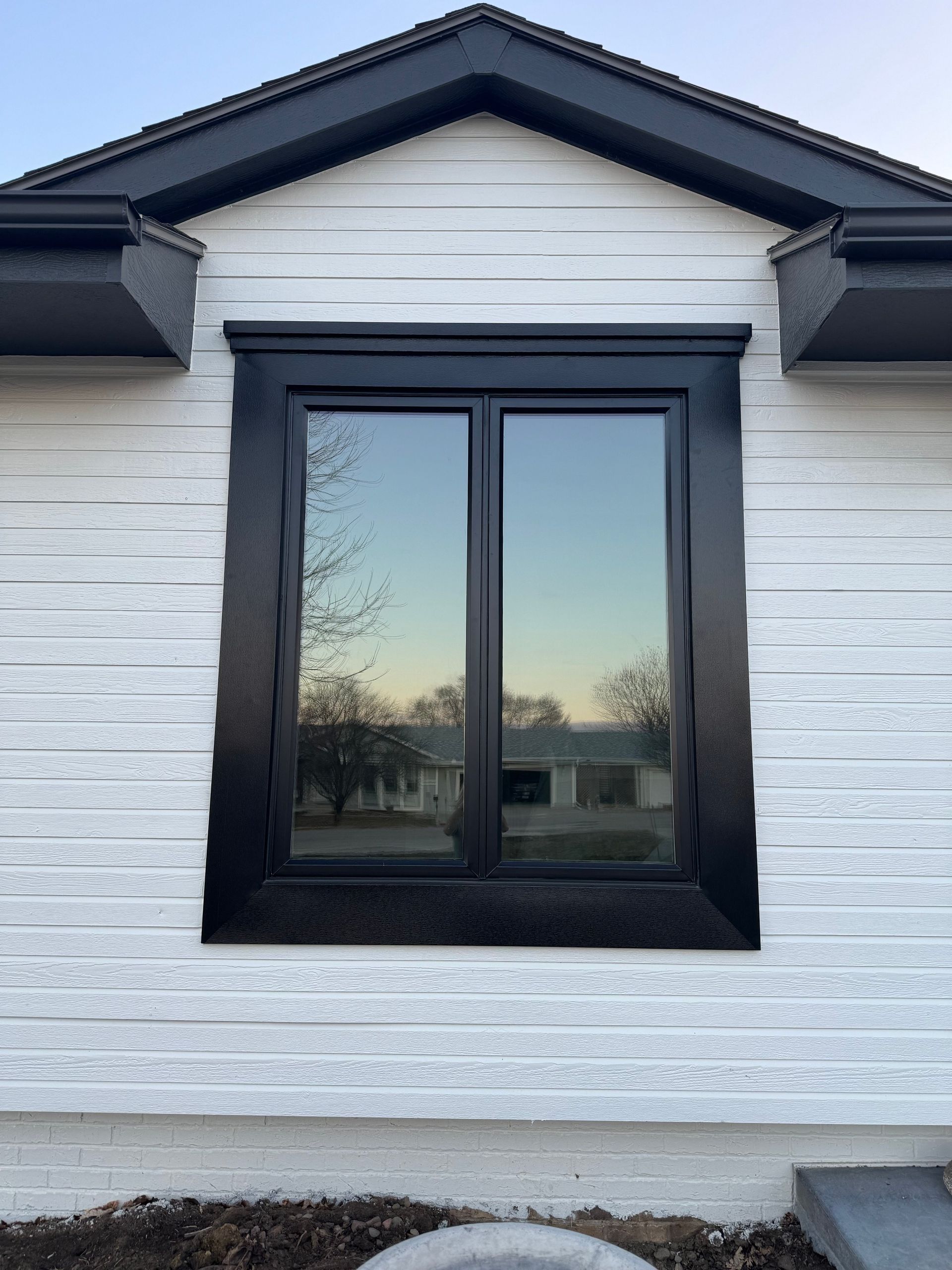 A white house with a black window on the side