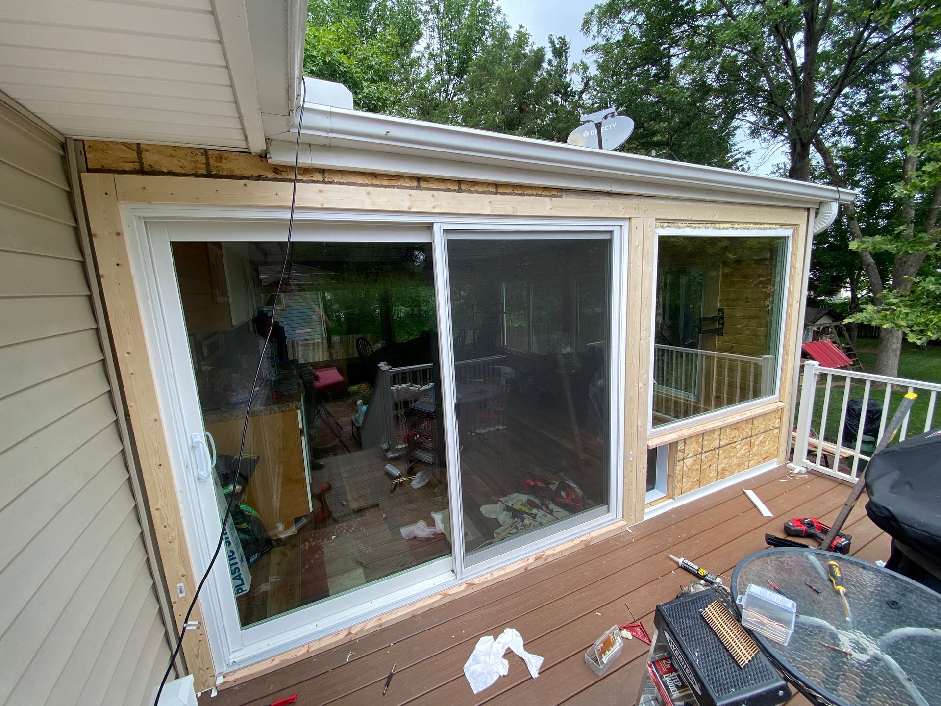 A sliding glass door is being installed on the side of a house.