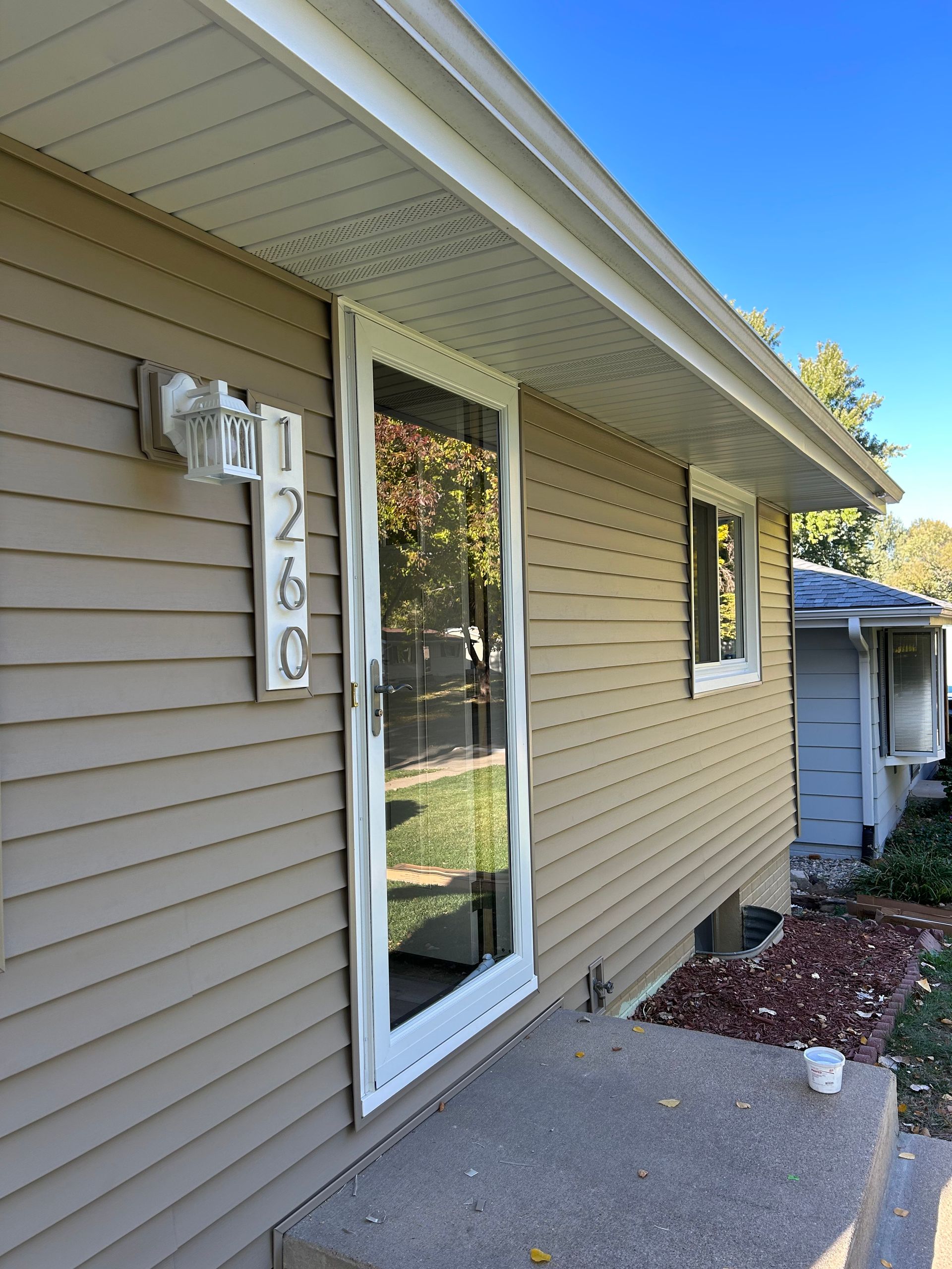 A house with a sliding glass door and a light on the side