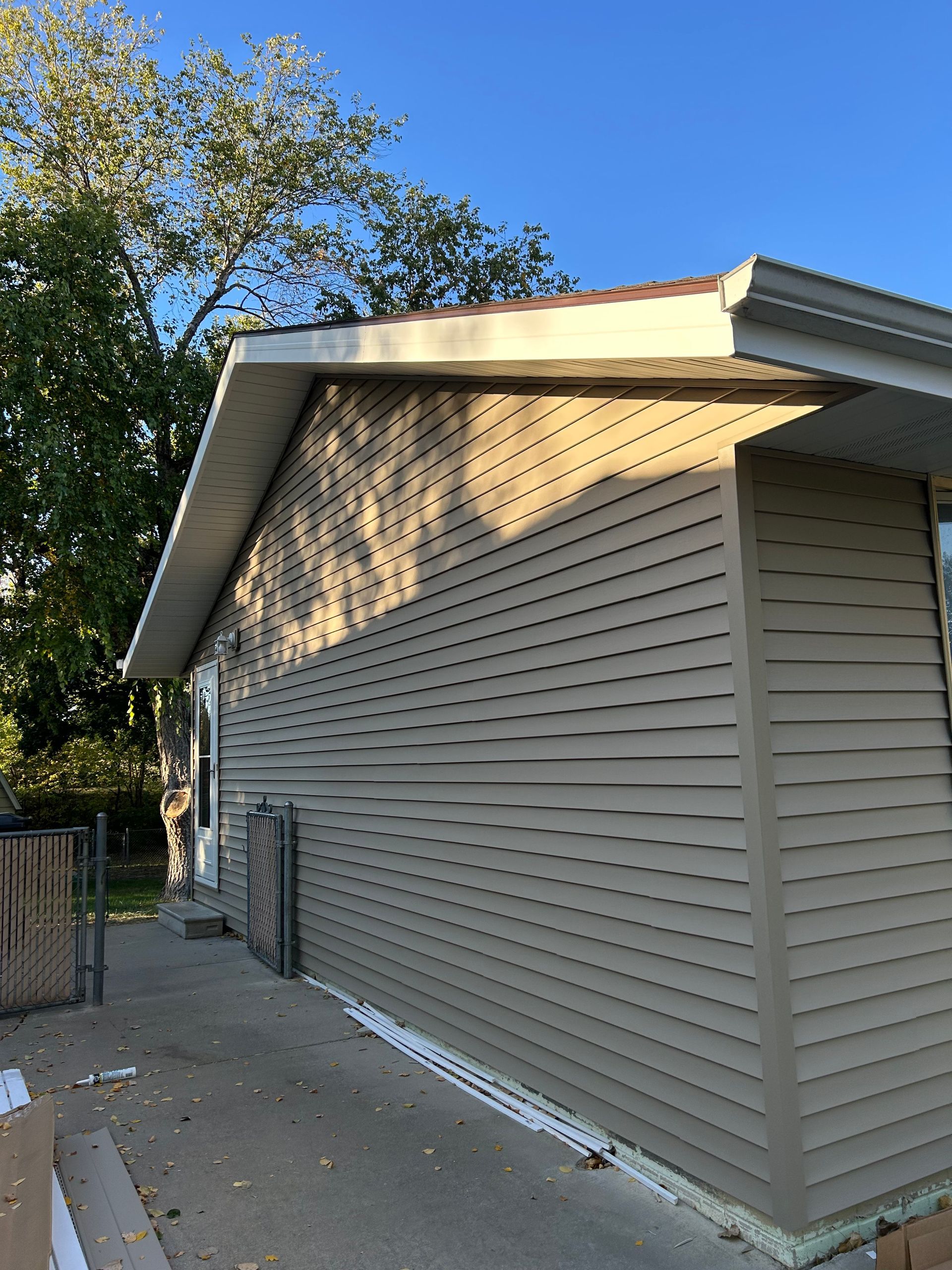 The side of a house with siding and a roof.