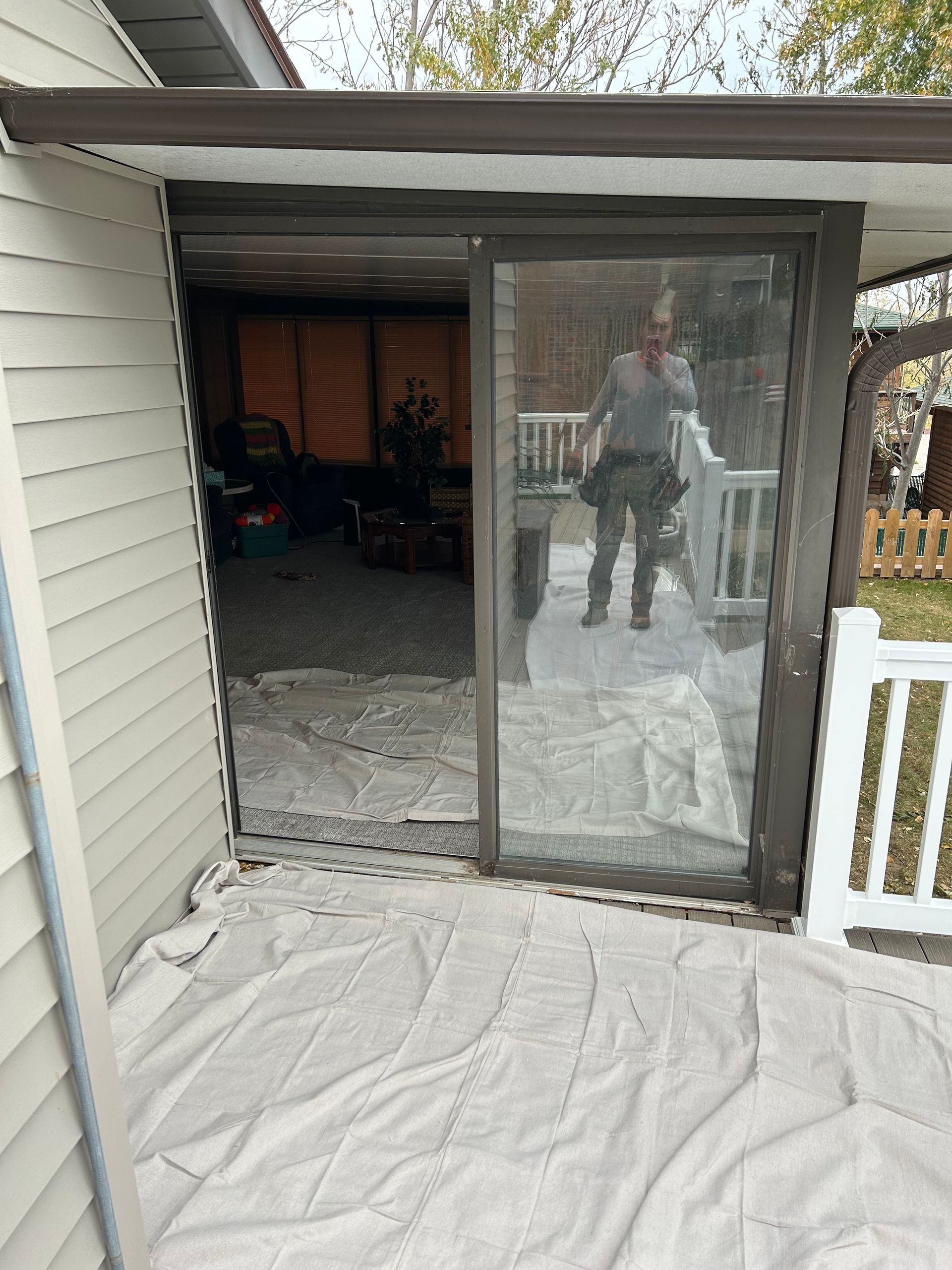 A man is standing in front of a sliding glass door.