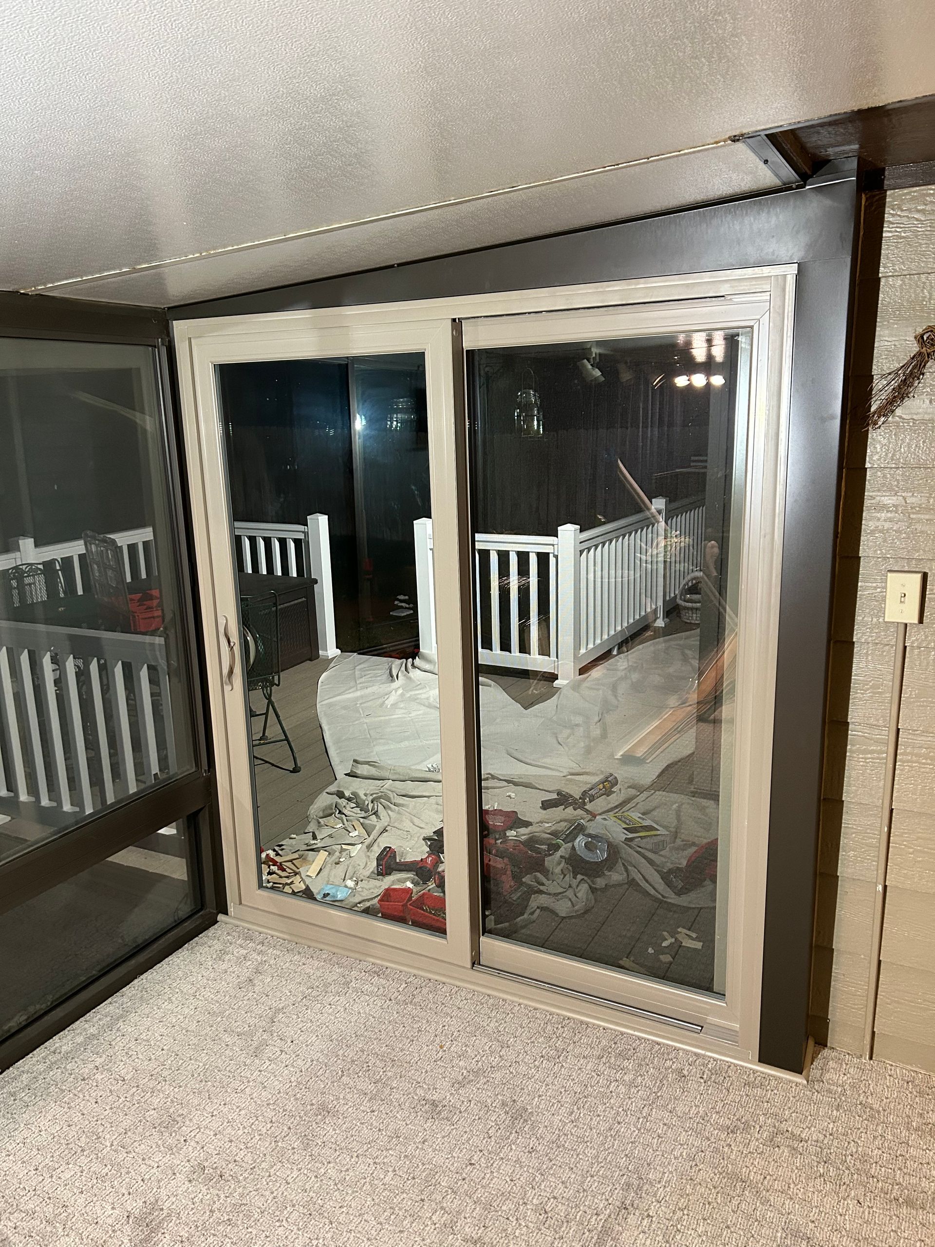 A sliding glass door in a room with a balcony in the background.