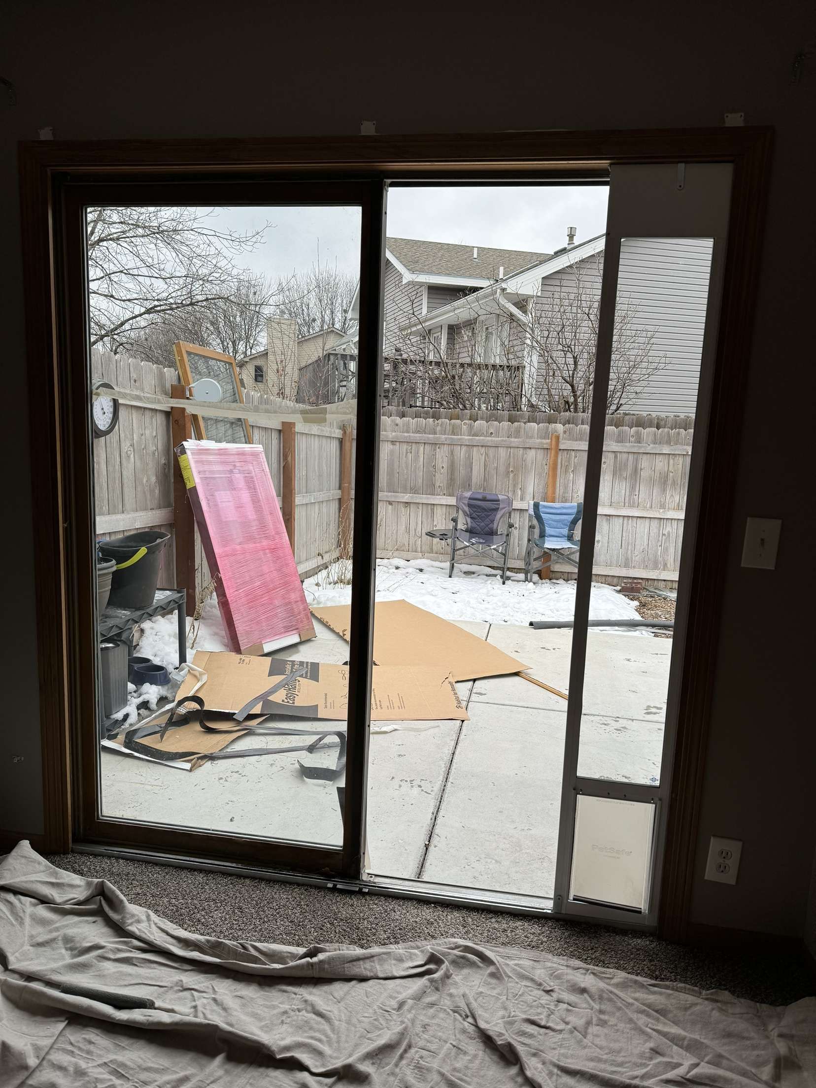 A room with a sliding glass door leading to a backyard.