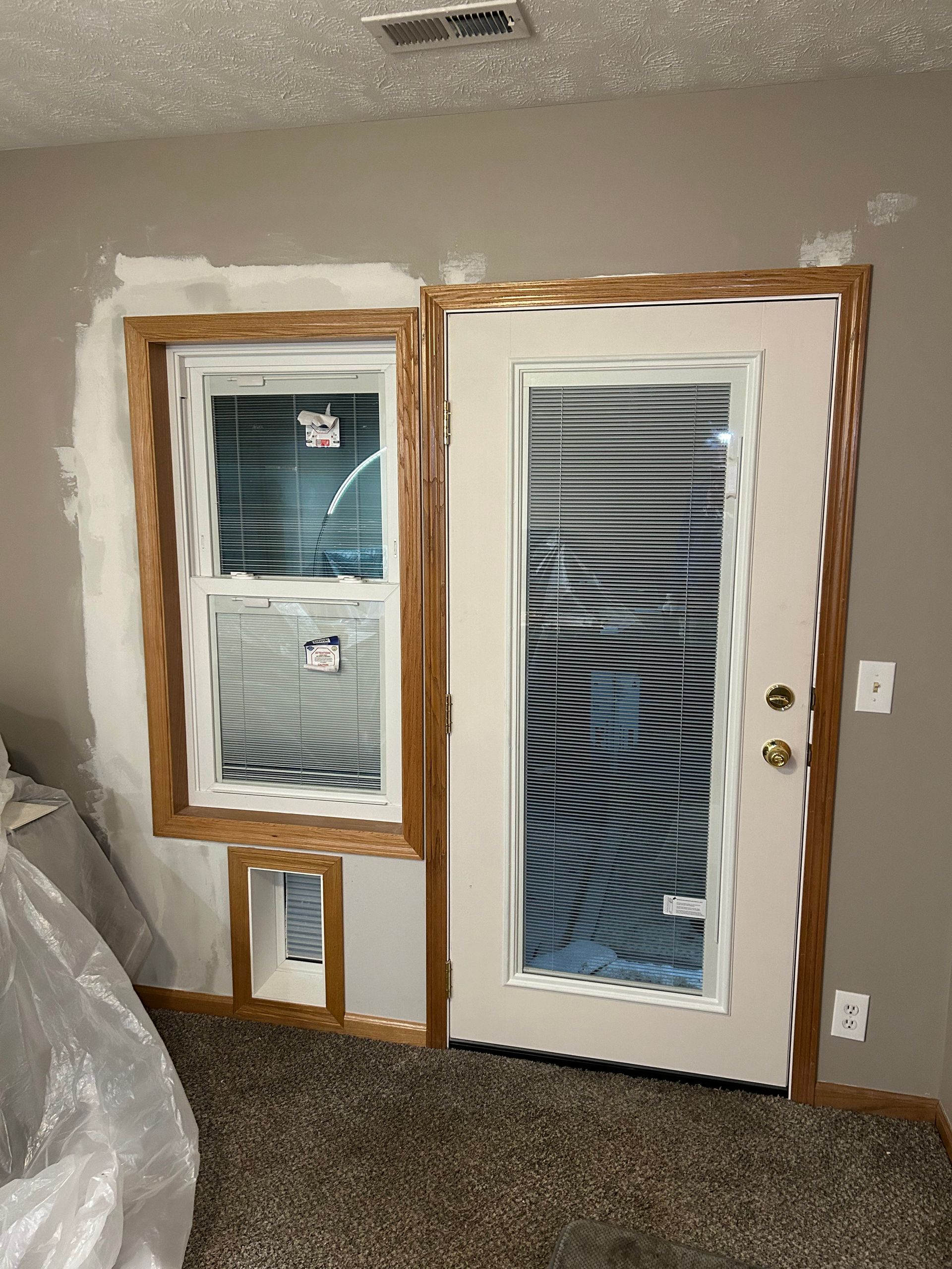 A room with a door and two windows in it.