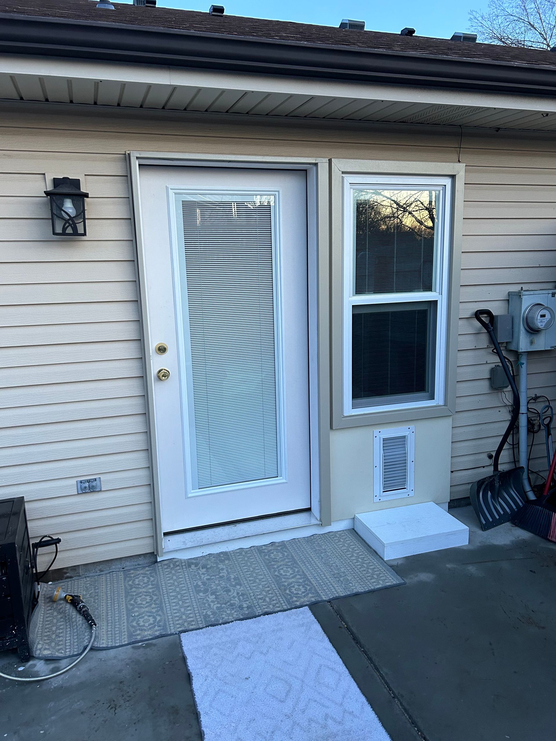 A white door with blinds and a window on the side of a house.