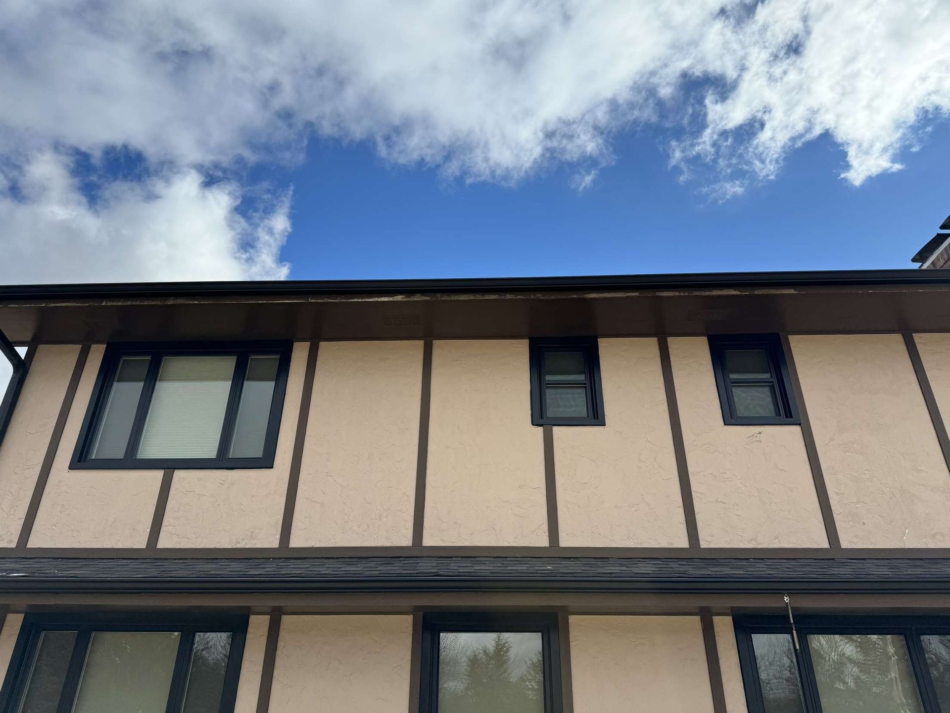 A house with a lot of windows and a blue sky in the background
