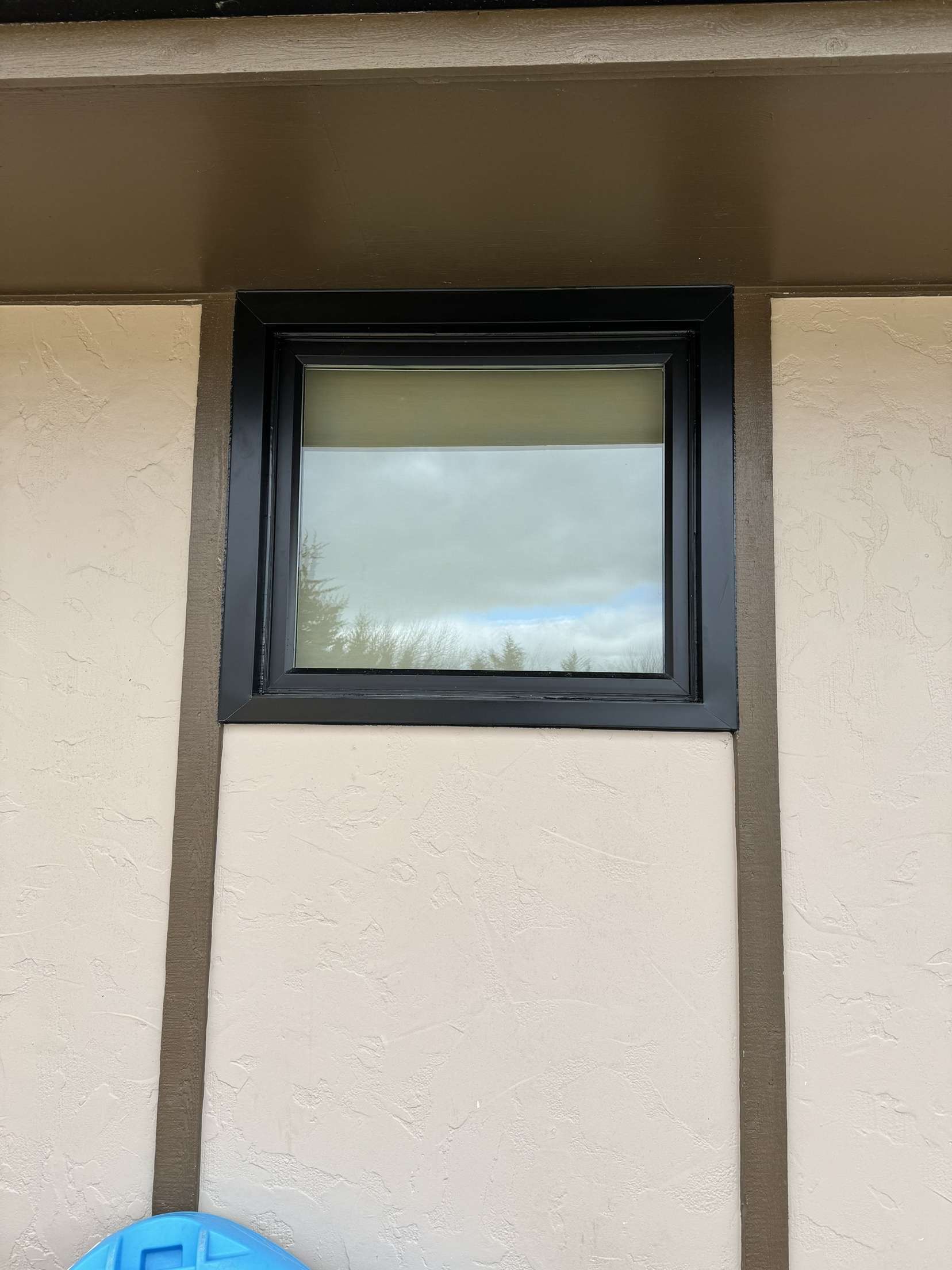 A window on the side of a building with a black frame.