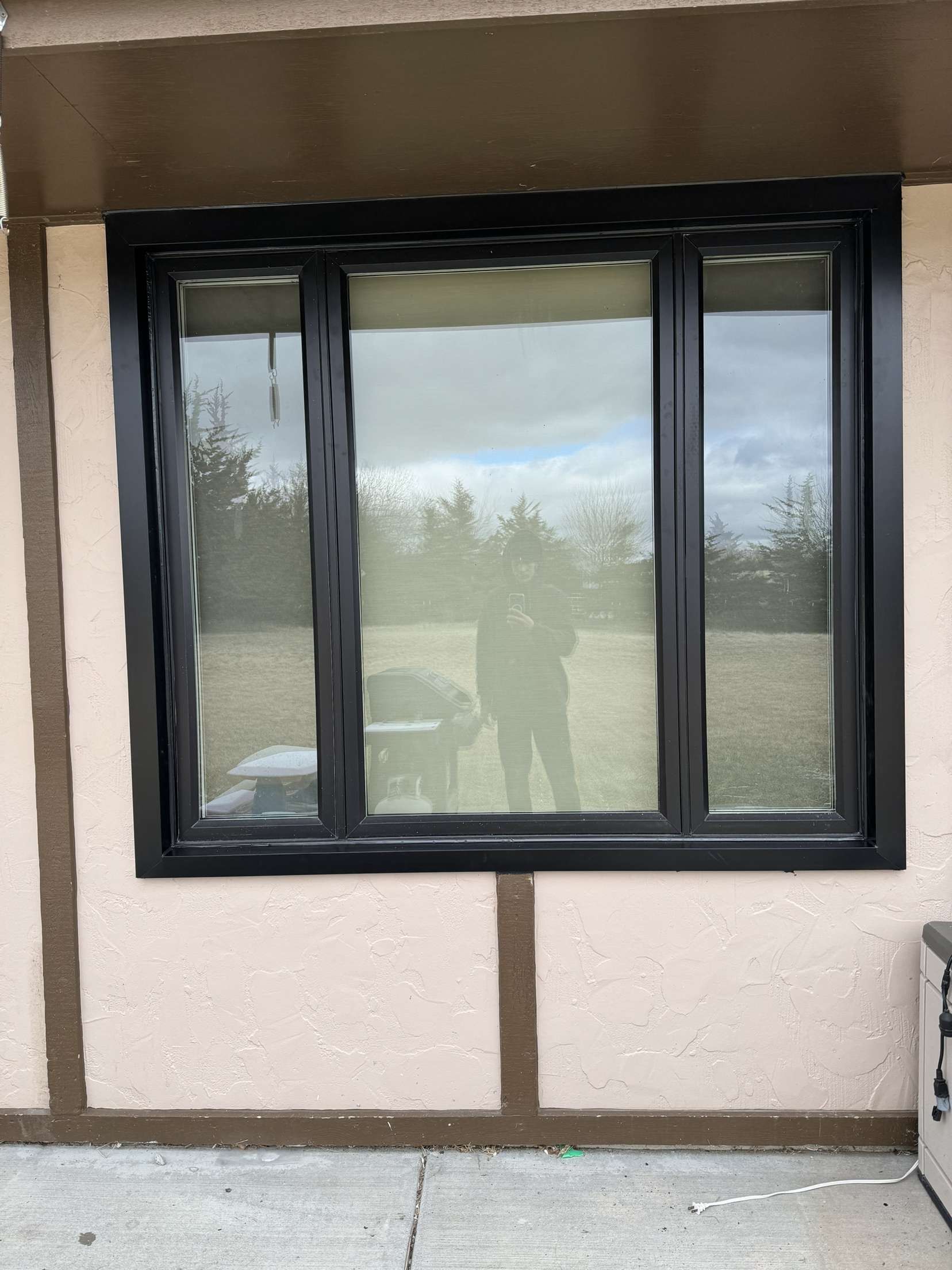 A large window on the side of a building with a reflection of a person in the window.