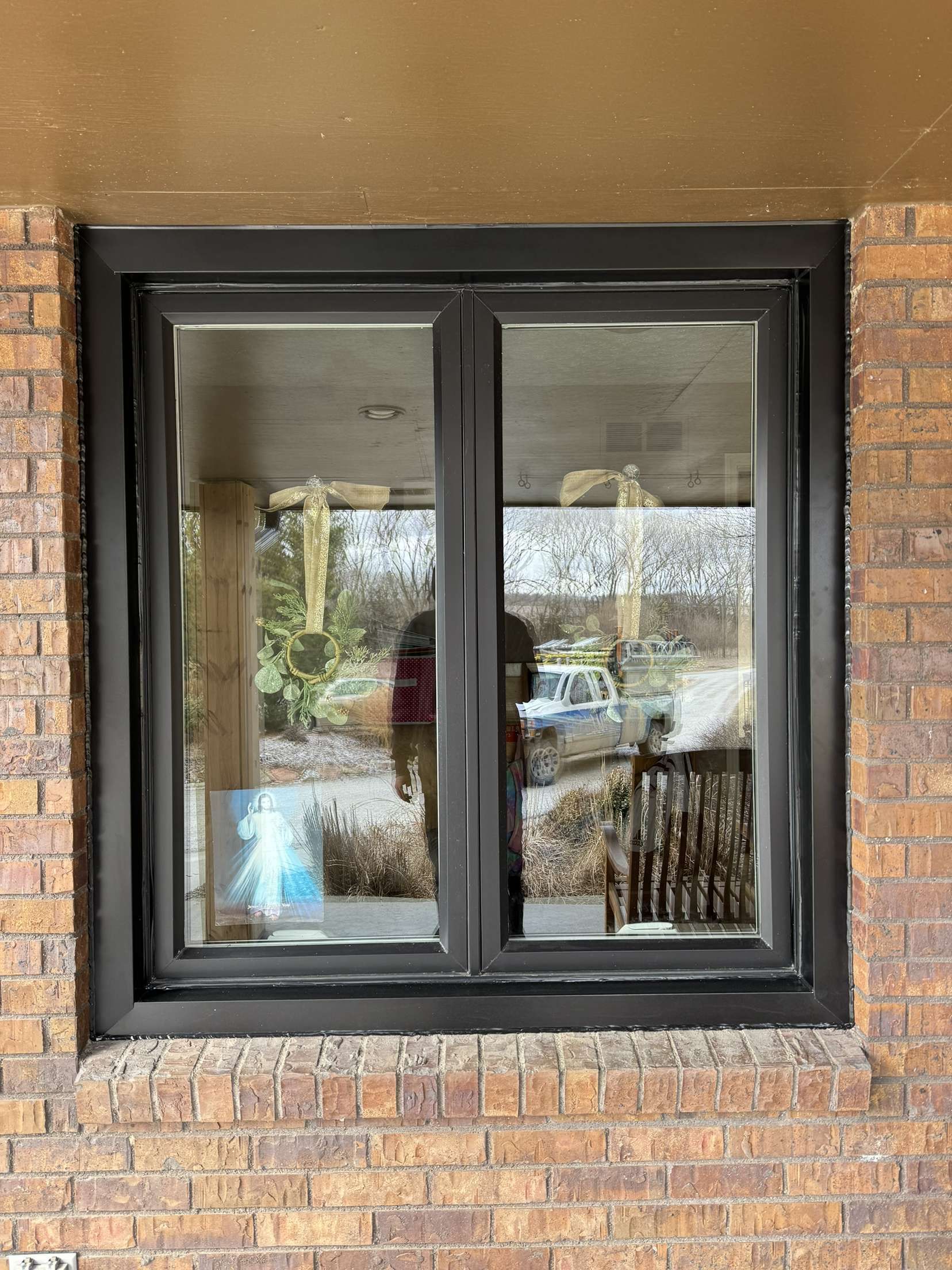 A window on a brick wall with a black frame.