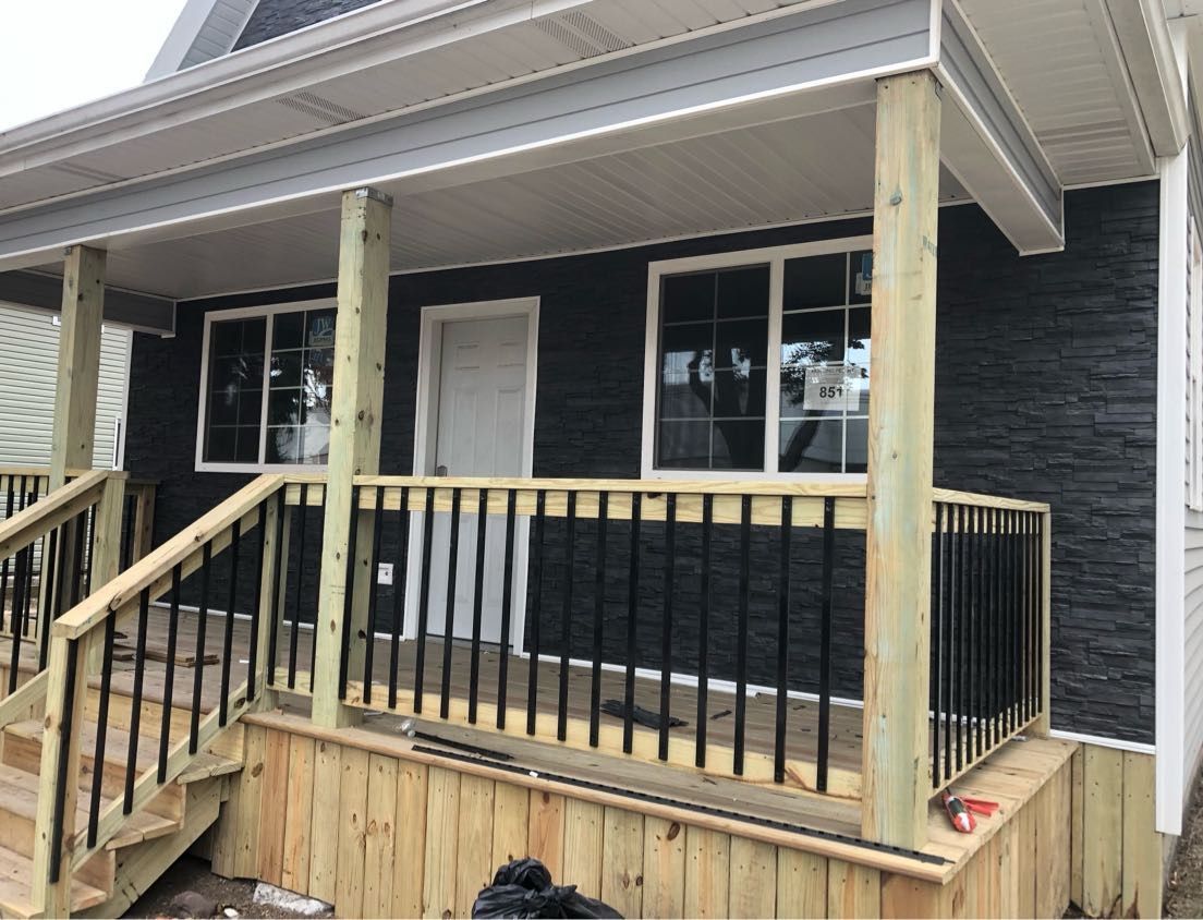 A black house with a wooden porch and stairs
