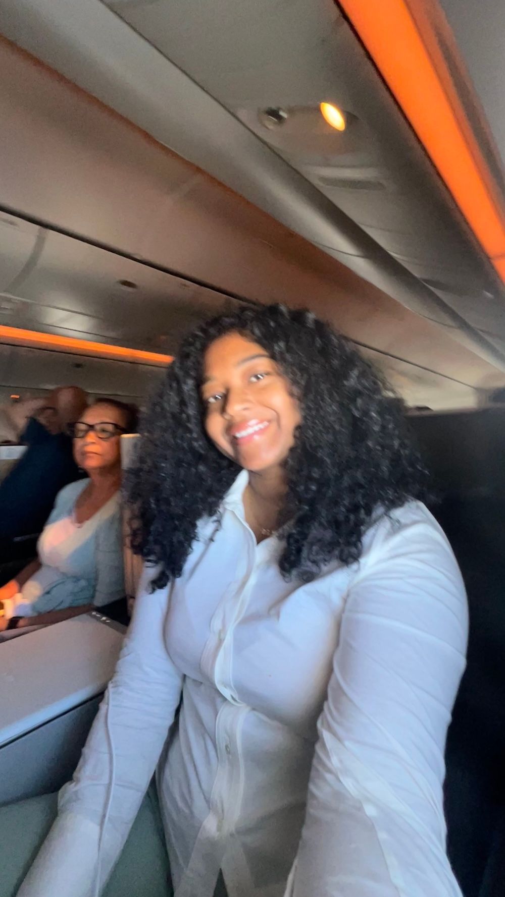Jess smiles from her seat in Swiss Airlines business class while her grandmother sits beside her. The flight moment adds another personal detail to the question of whether Switzerland is worth visiting.
