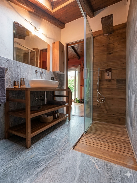 Parete dipinta di giallo con una scala, pluriball e un soggiorno sullo sfondo.