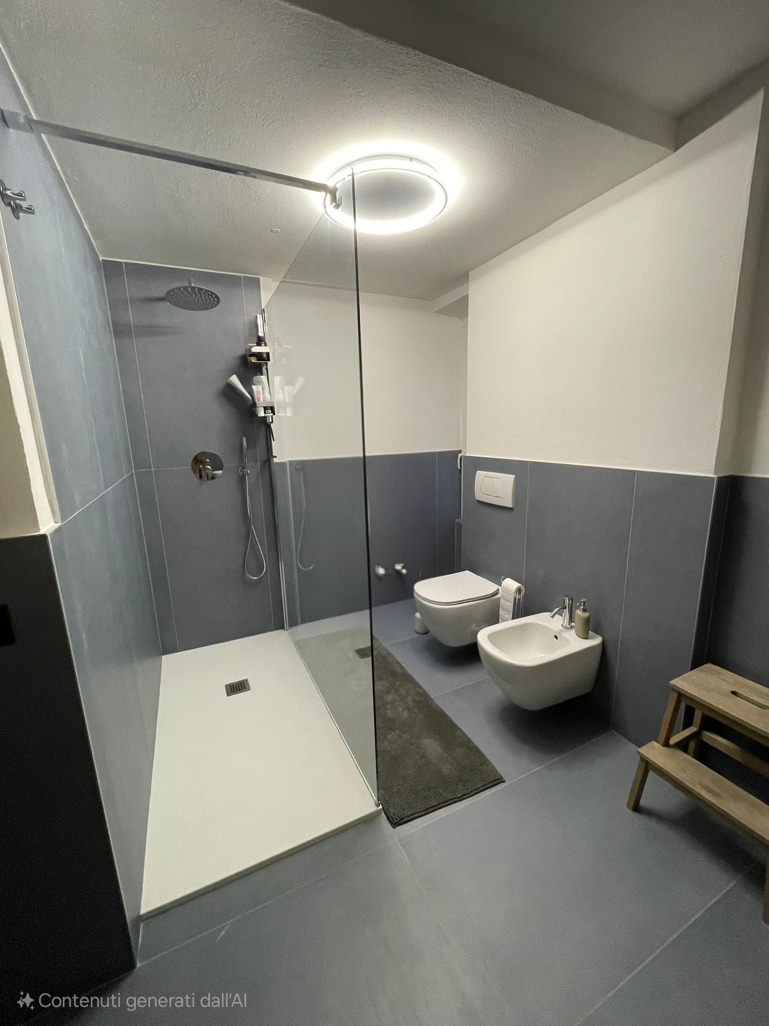 Bagno moderno con doccia, WC e bidet. Piastrelle grigie e bianche, lampadario. Sgabello in legno.