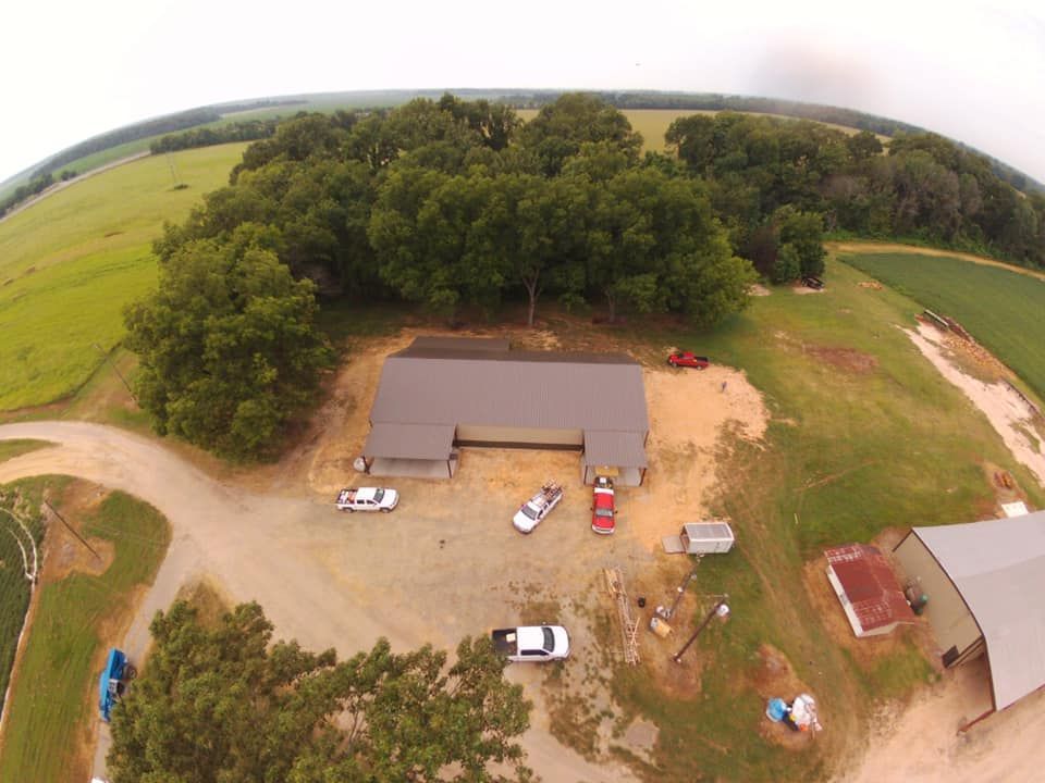 An aerial view of a farm with a house and a lot of trees.