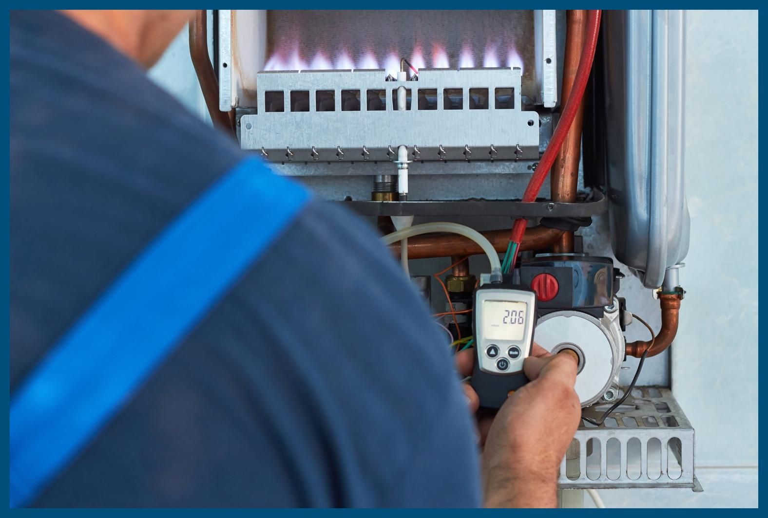 A man is working on a boiler with a digital thermometer in his hand.
