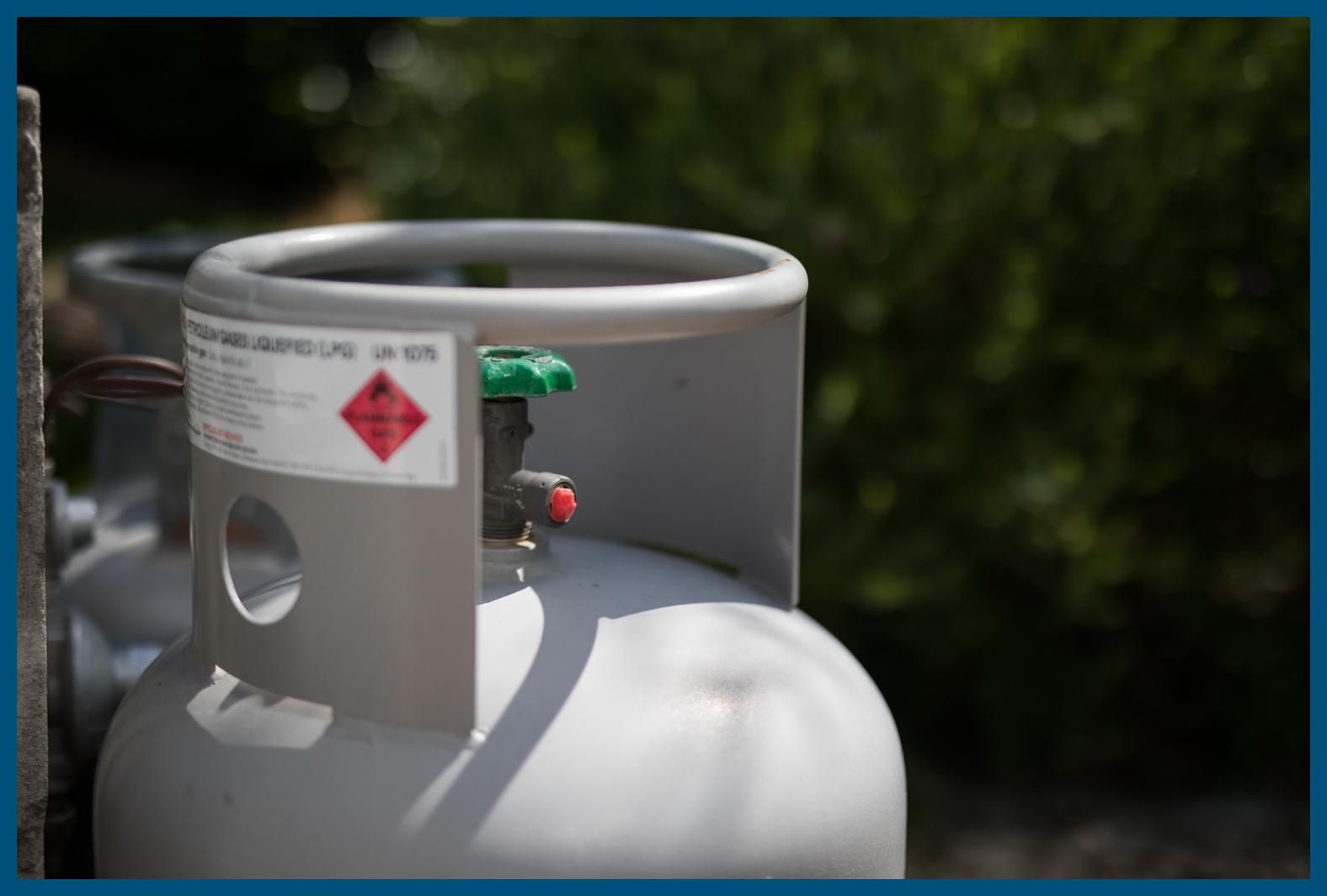 A close up of a gas cylinder with a green valve