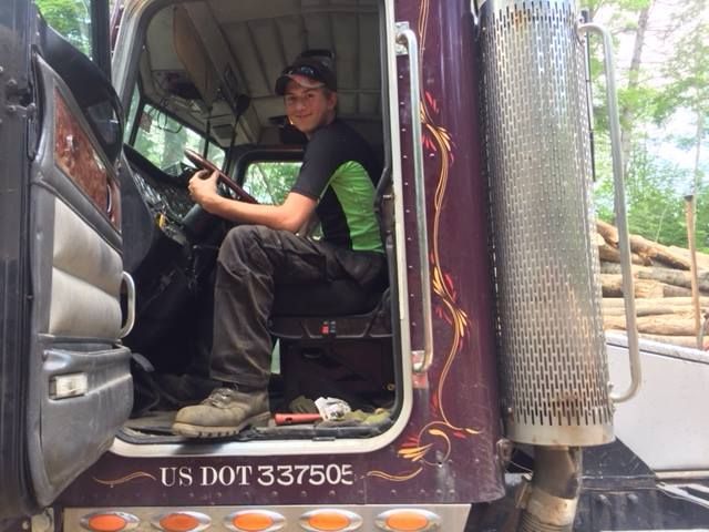 A man is sitting in the driver 's seat of a truck that says us dot 33750e