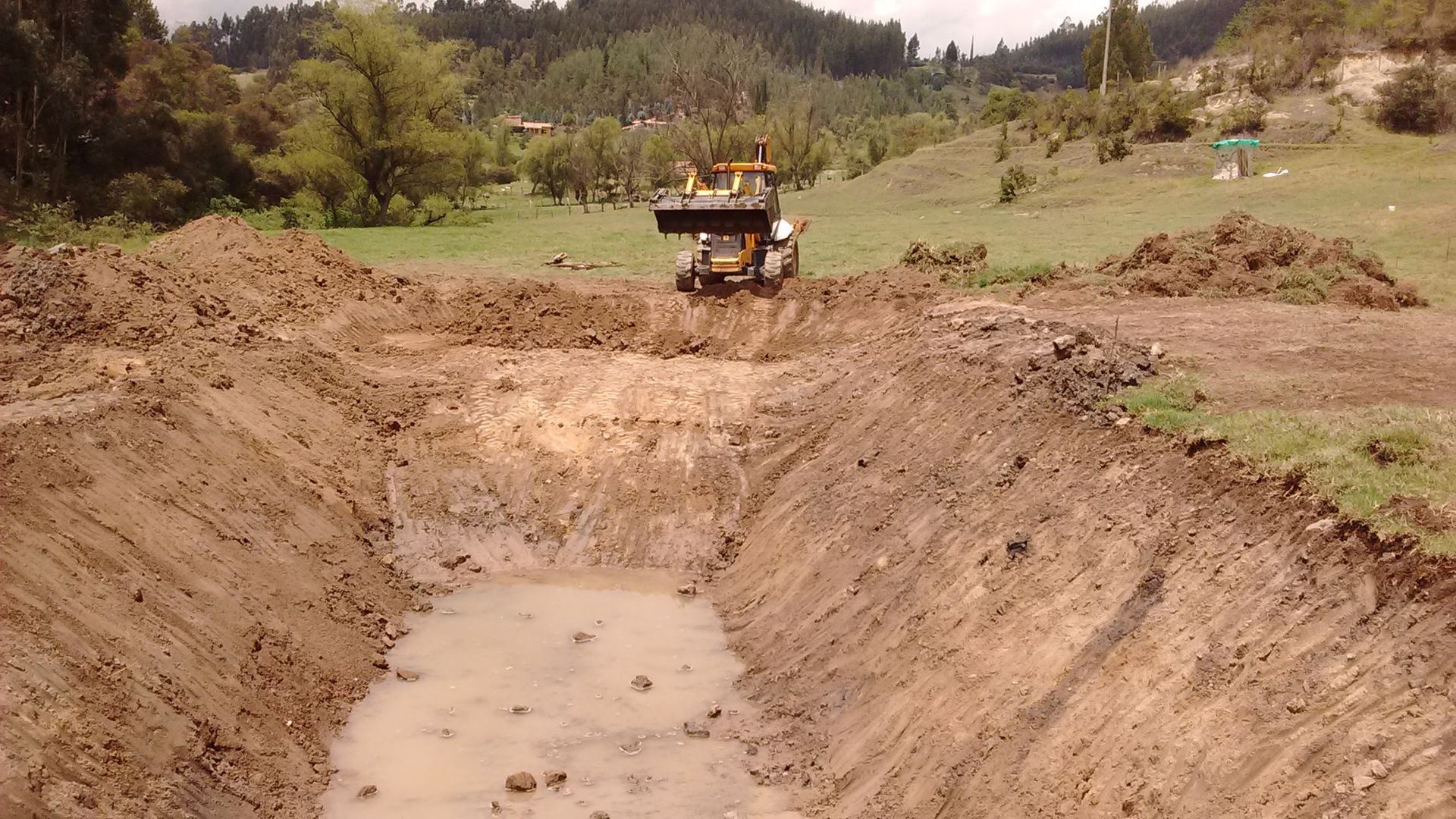 A bulldozer is driving through a muddy field