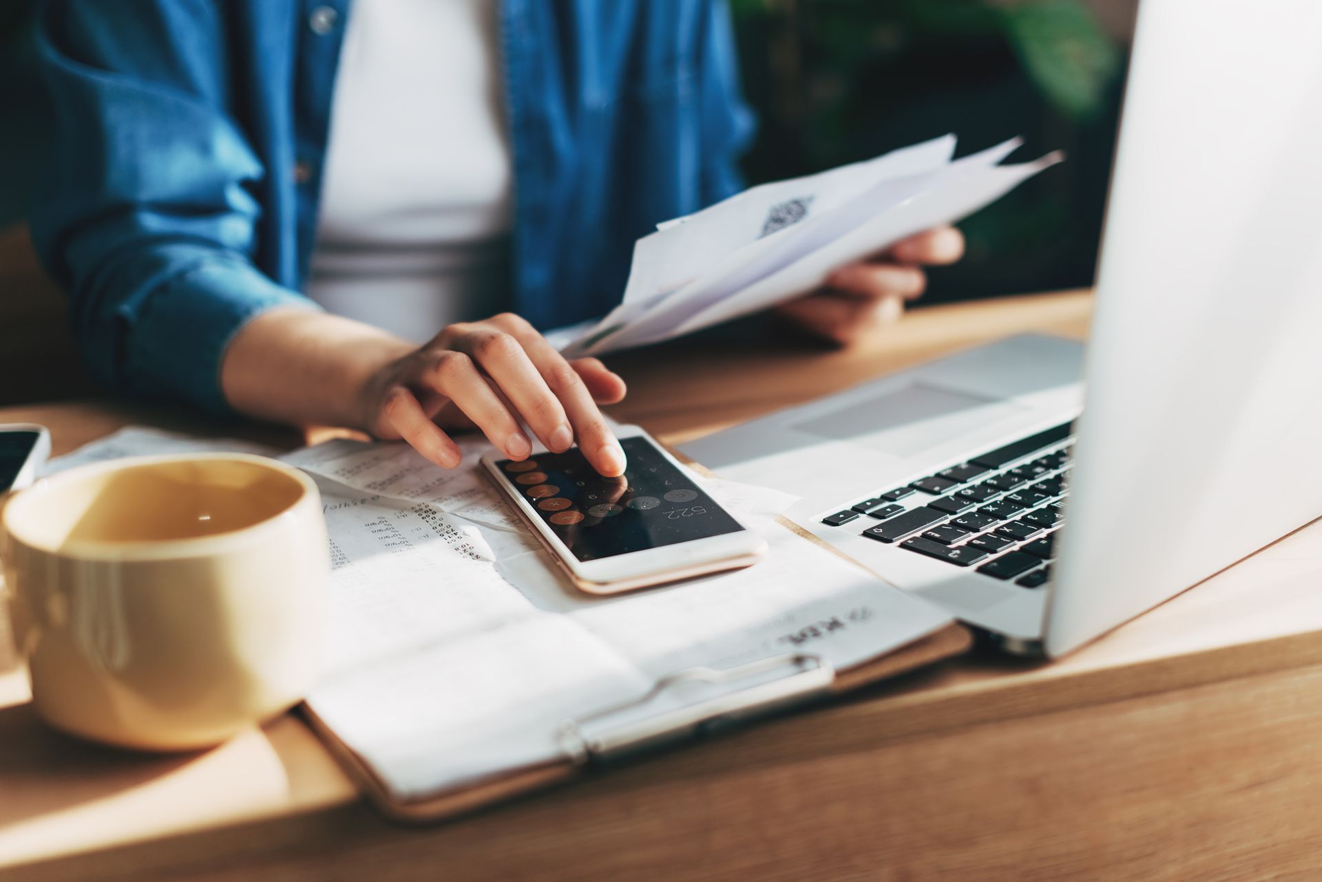 Businesswoman using a calculator and laptop to keep track of her business accounting. Businesswoman using a calculator and laptop to keep track of her business accounting.