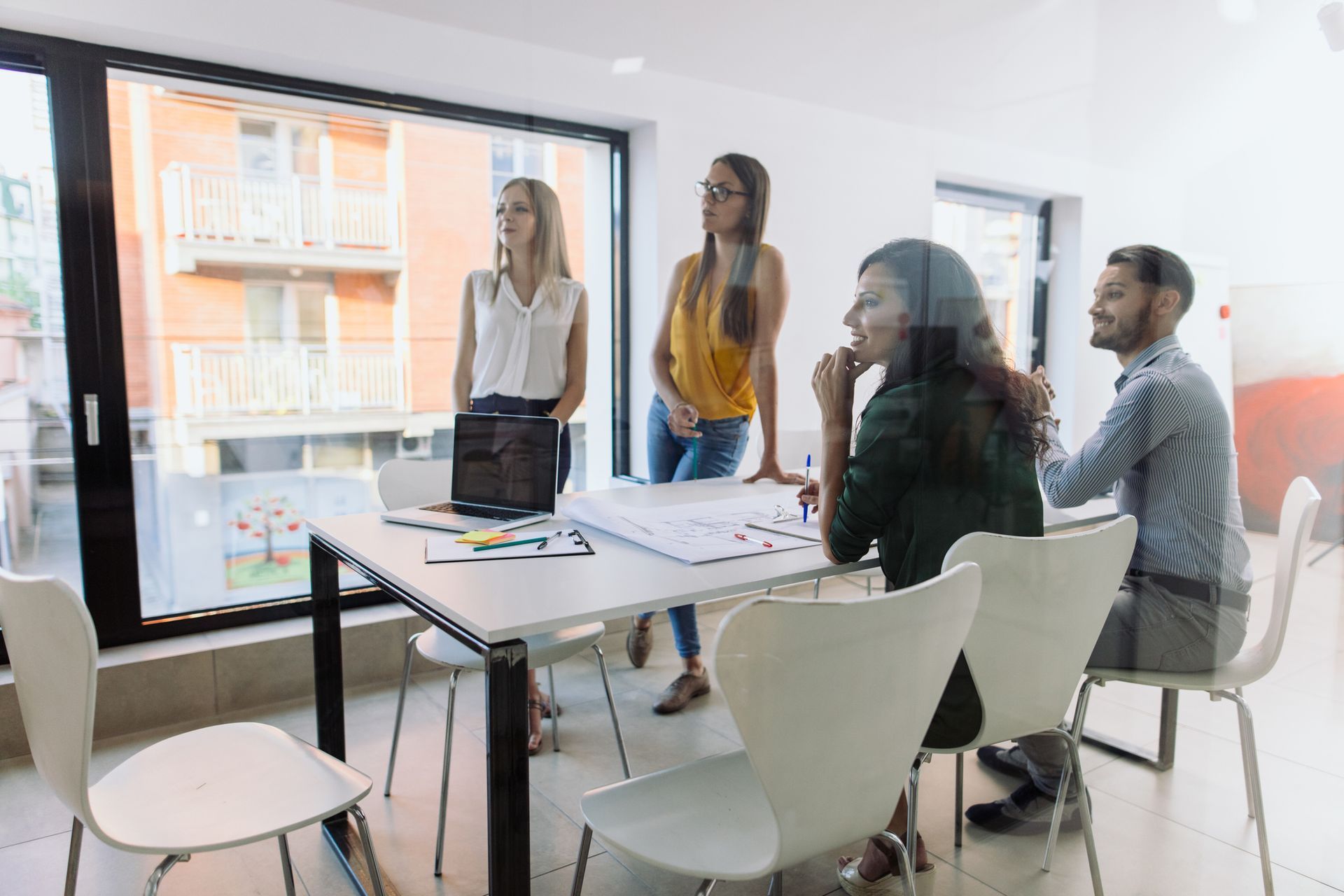 A Group Of People Sitting Around A Table With A Laptop On It - Hobart, TAS - Stuart Iles Partners