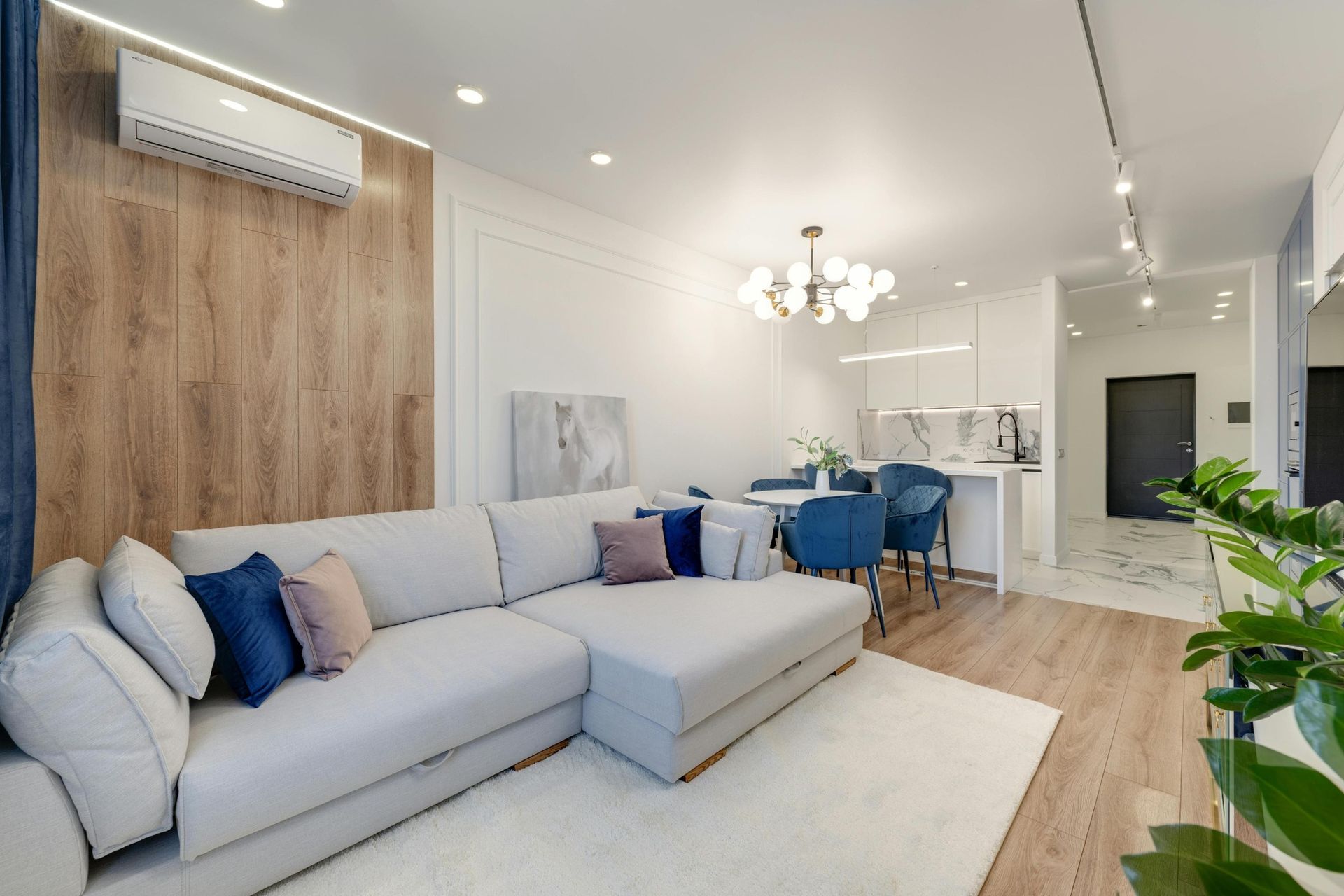 A living room with a white sectional couch and blue chairs.