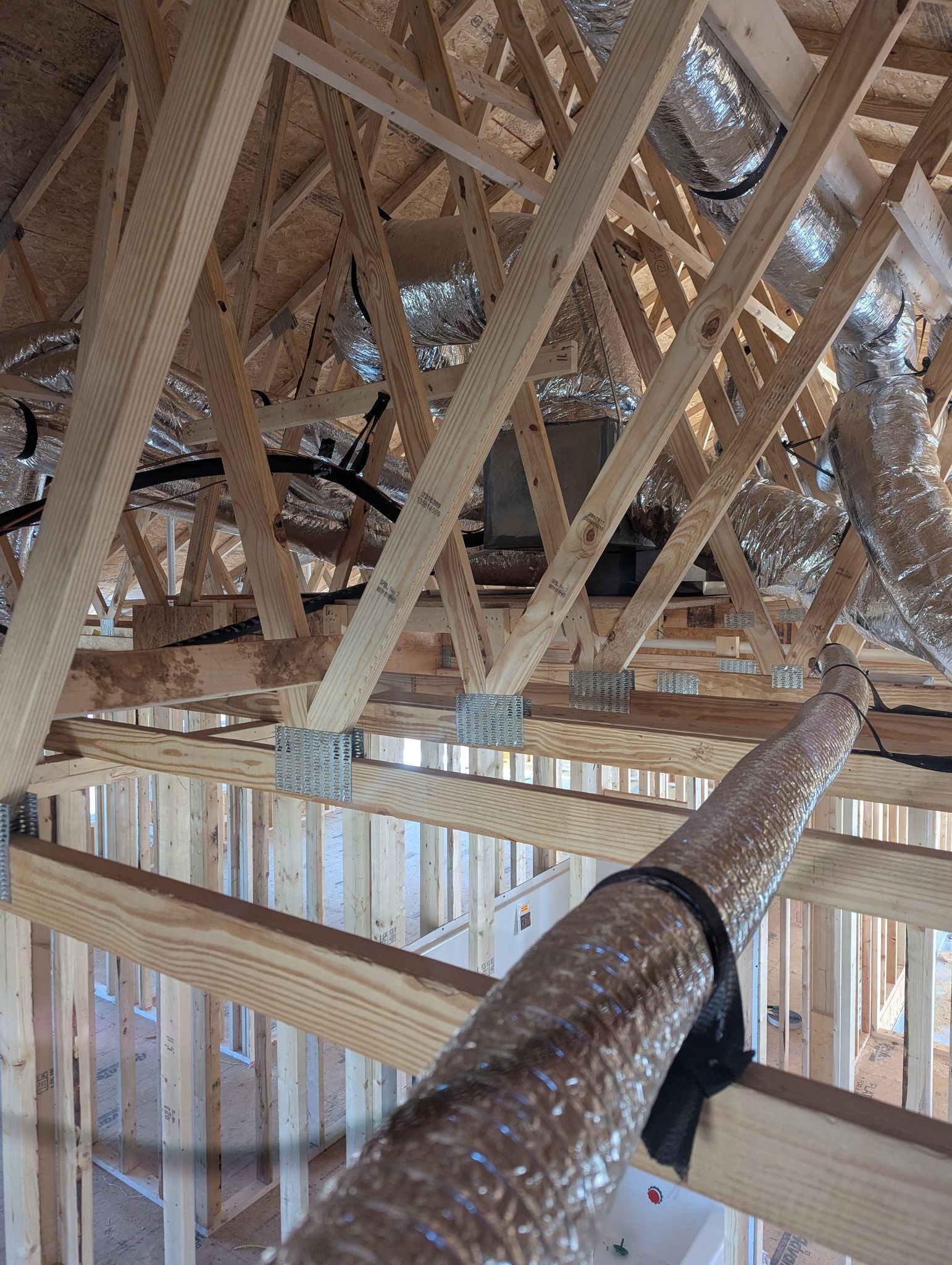 A house is being built with a lot of wood and aluminum ducting.