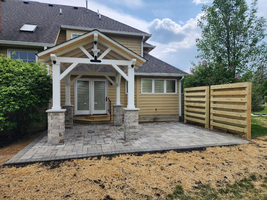 A house with a patio and a wooden fence in front of it.