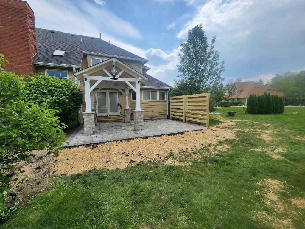A house with a patio and a wooden fence in the backyard.