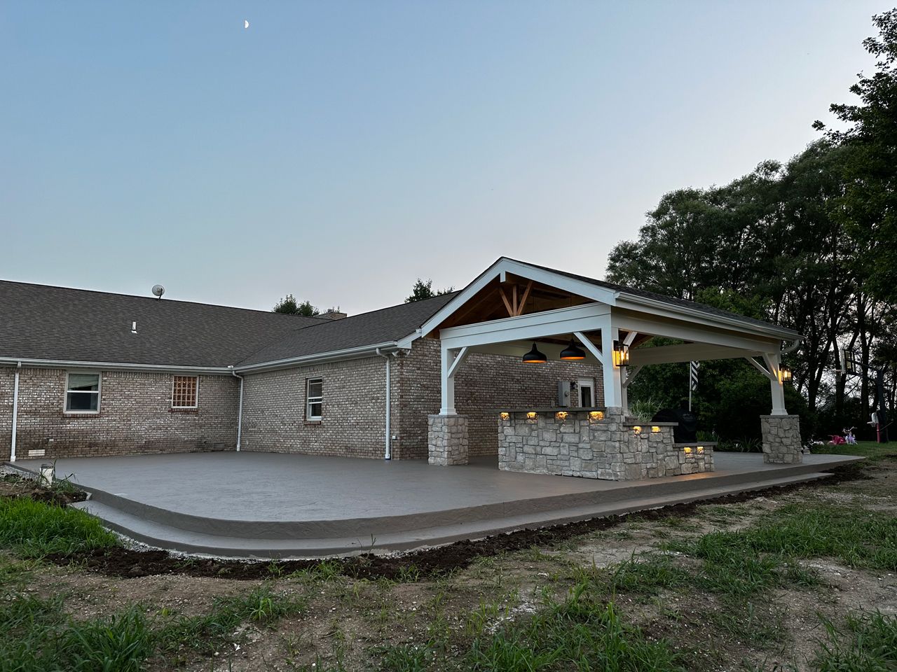A large house with a large patio and a pavilion in the backyard.