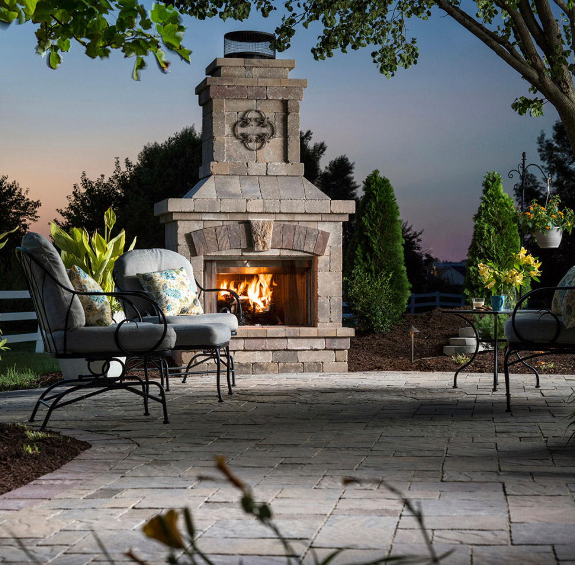 A patio with chairs and a fireplace with a cross on it
