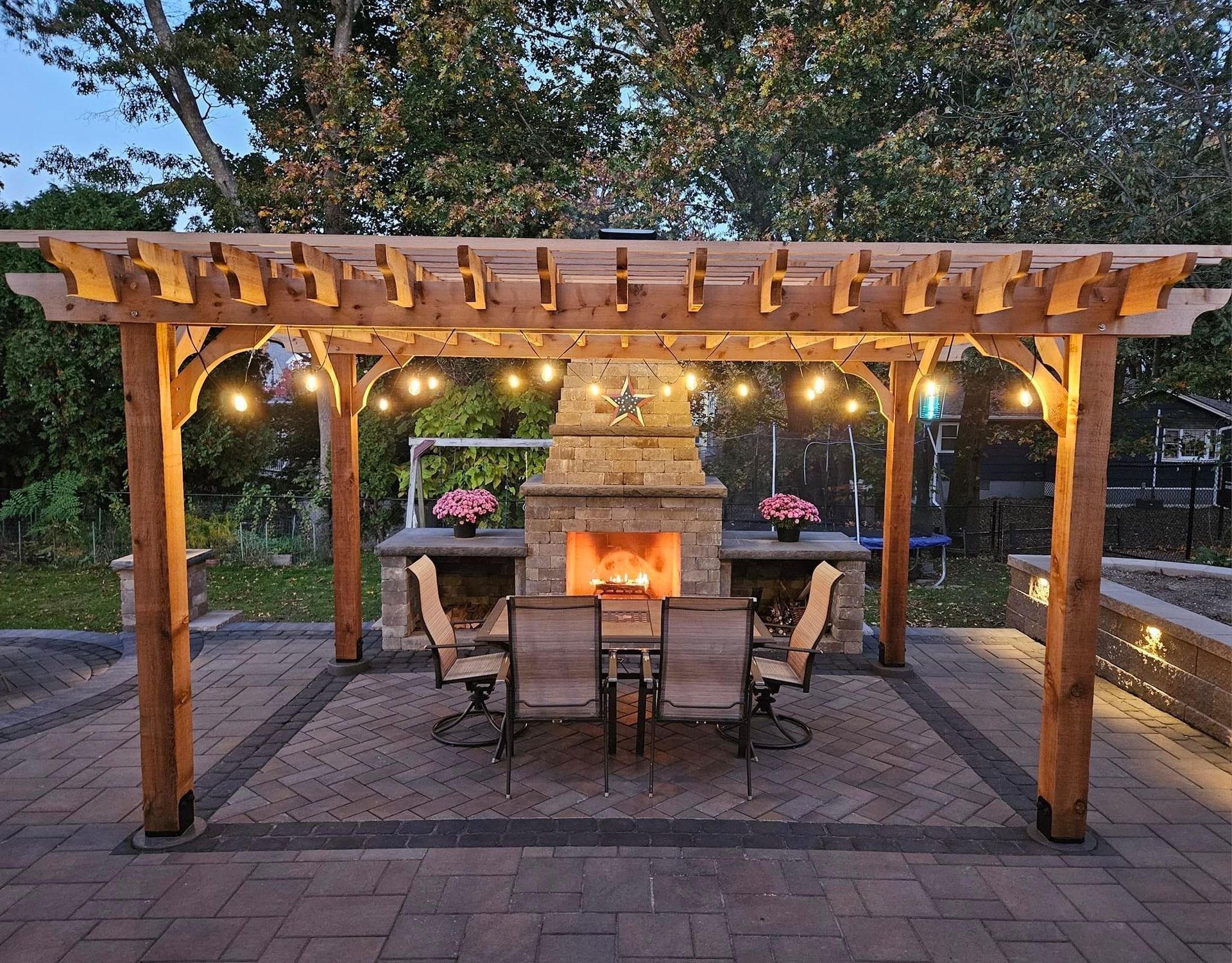 A patio with a pergola and a fireplace