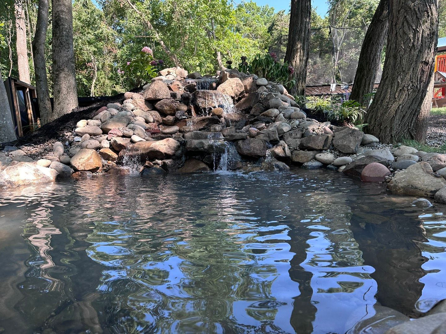 There is a waterfall in the middle of the woods.