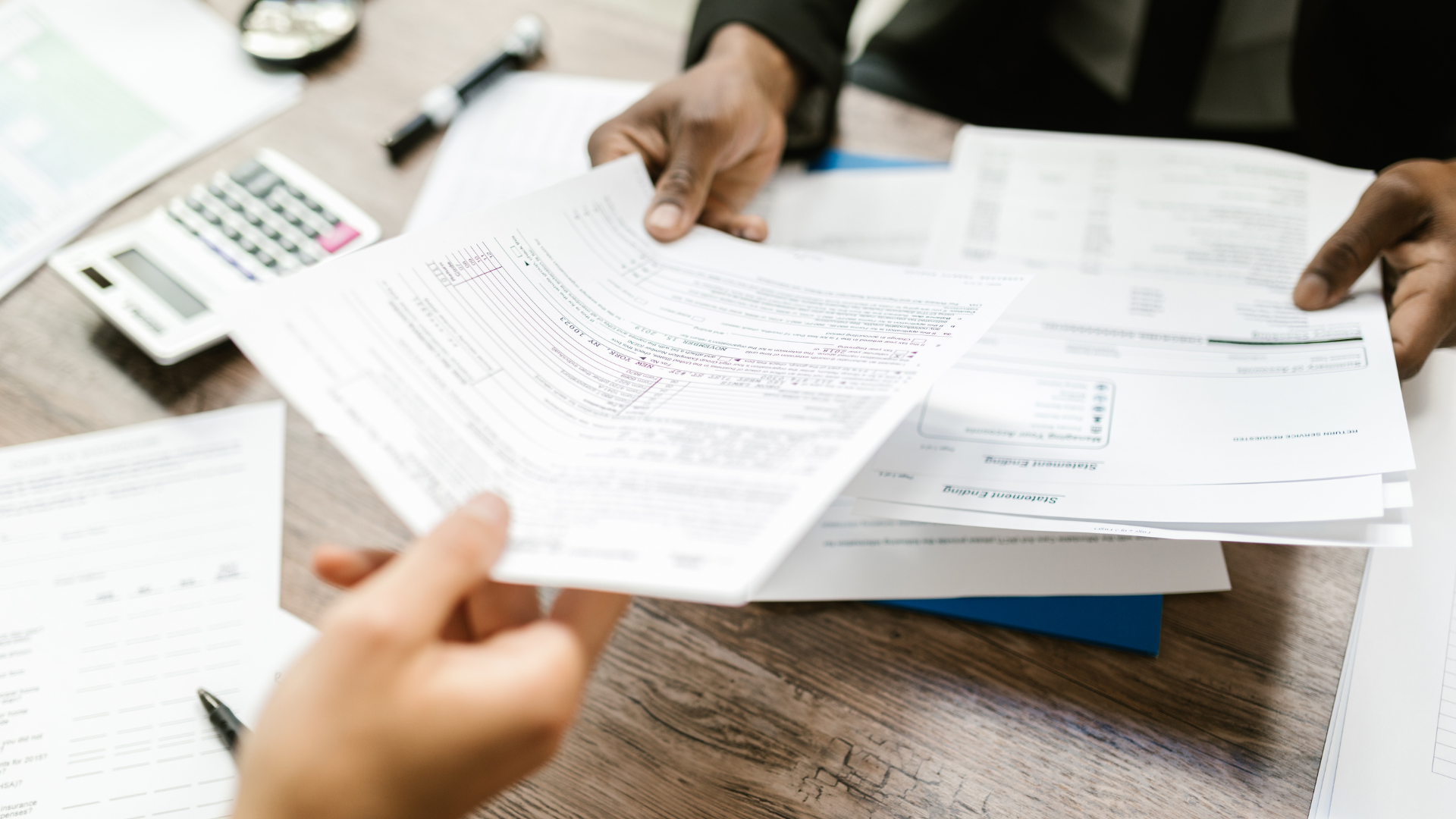 A pen and glasses are on top of a 1040 tax form