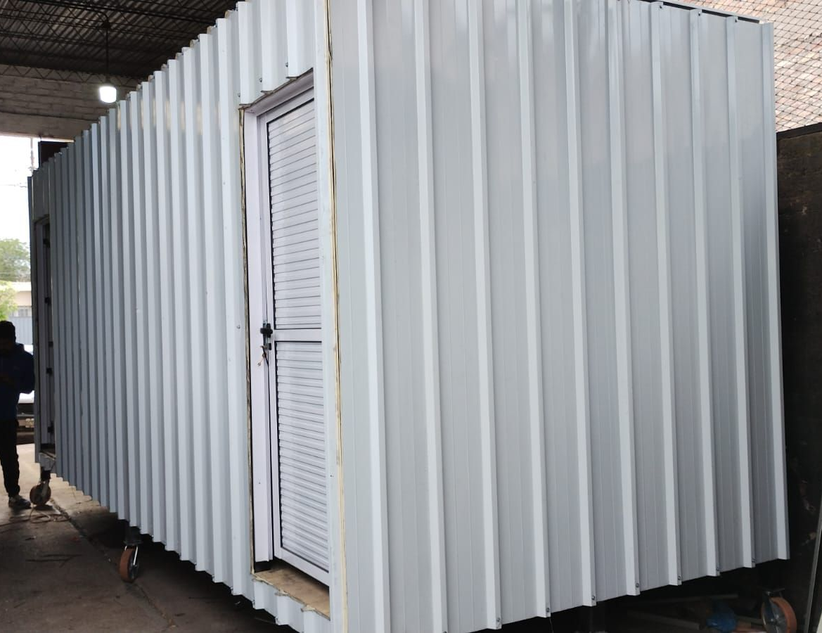 Una camioneta roja está estacionada frente a un edificio en construcción.