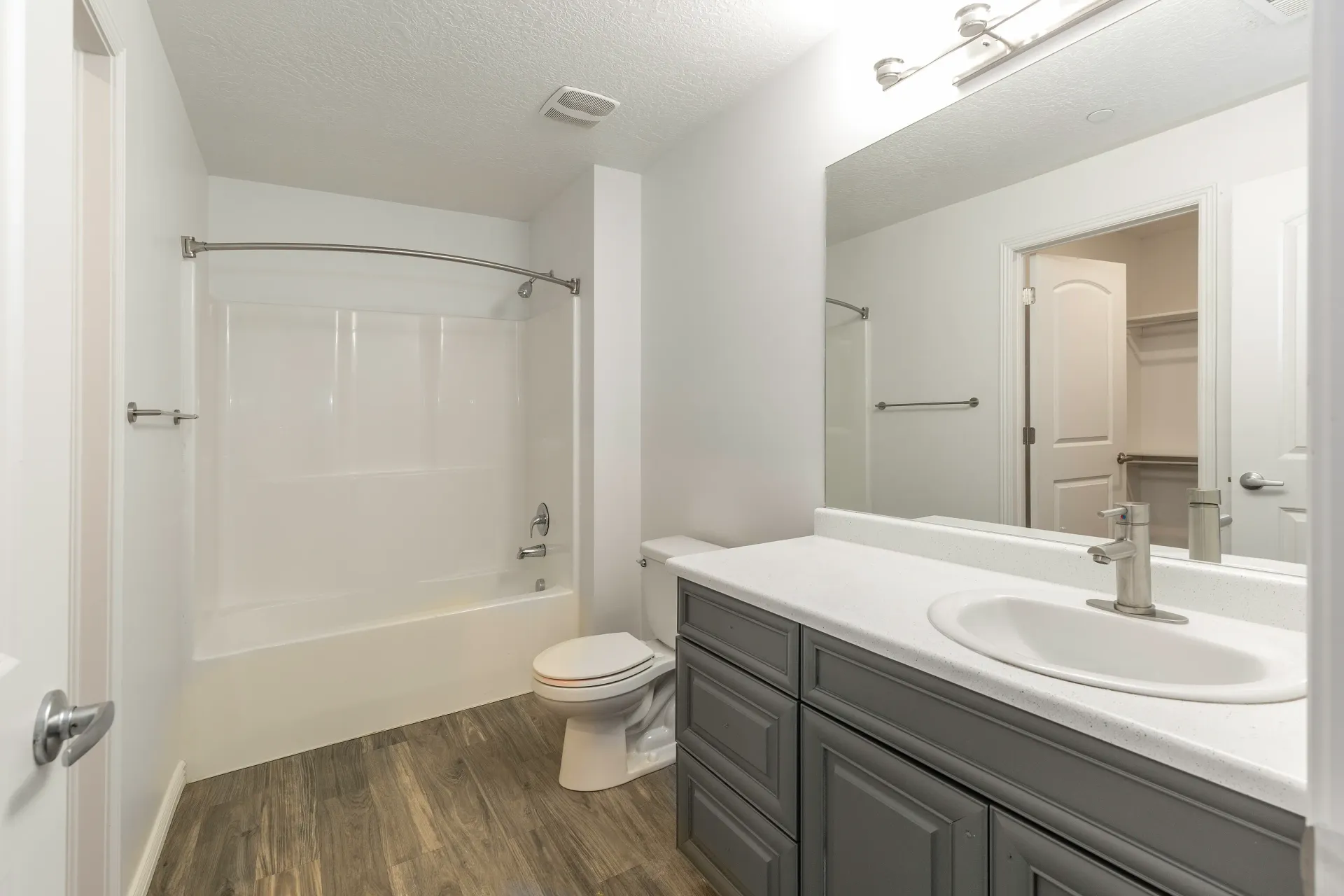 Modern bathroom with vanity, sink, toilet, and bathtub with shower.