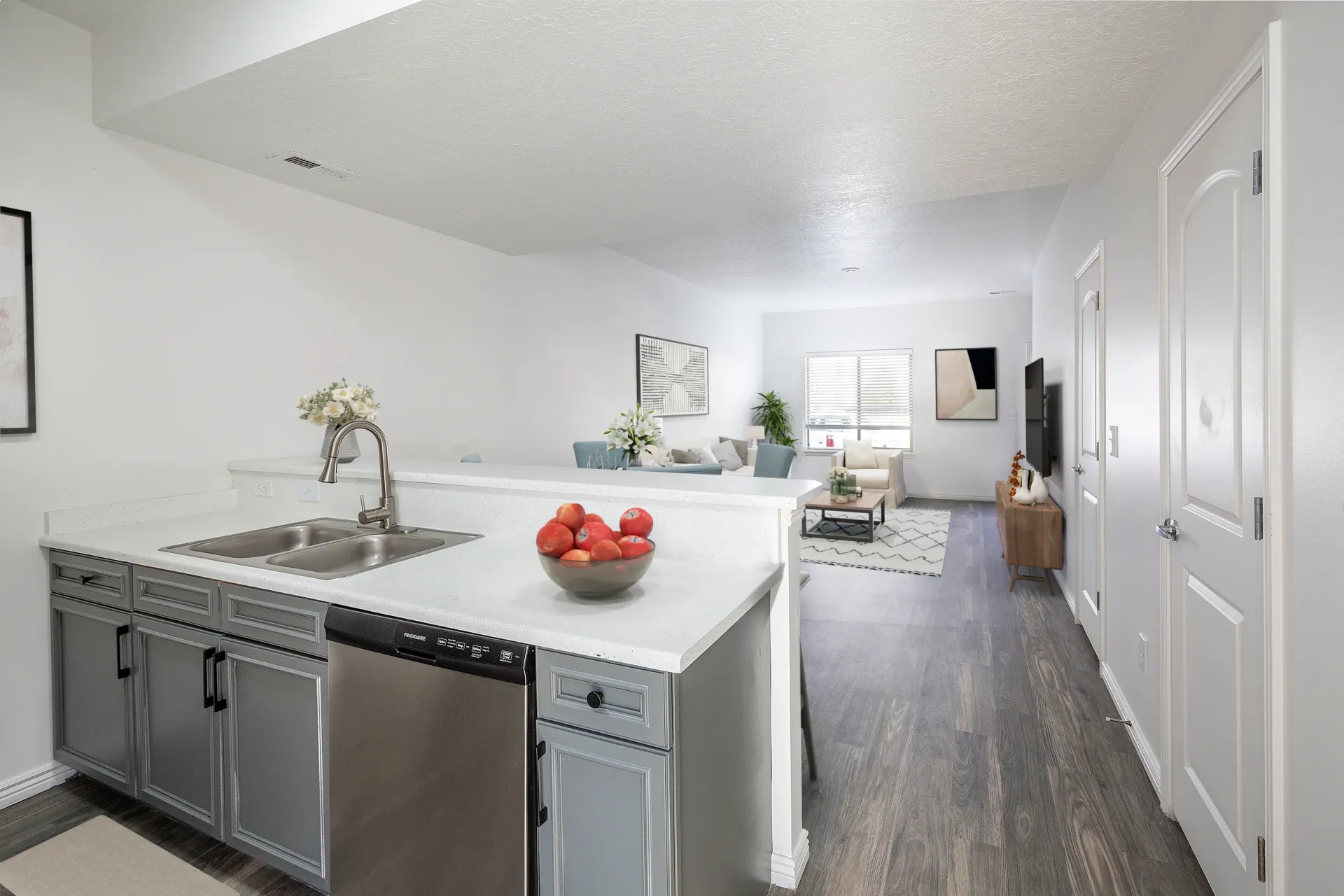 Modern kitchen with stainless steel appliances and a view into the living room.
