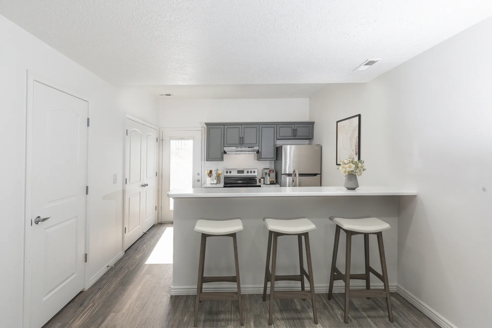 Kitchen with granite countertops, stainless steel appliances, and breakfast bar with stools.