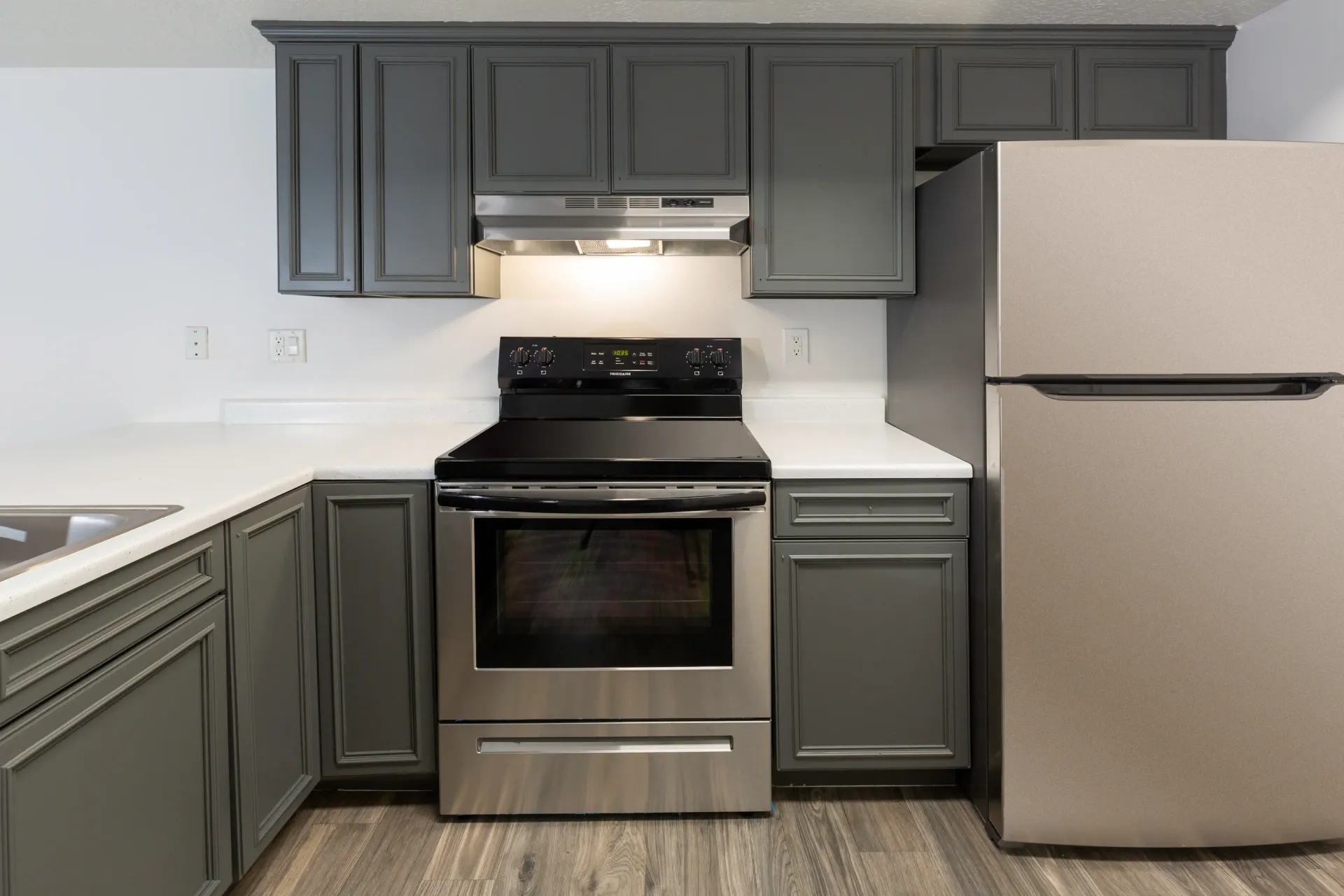 Modern kitchen with stainless steel appliances and gray cabinets.