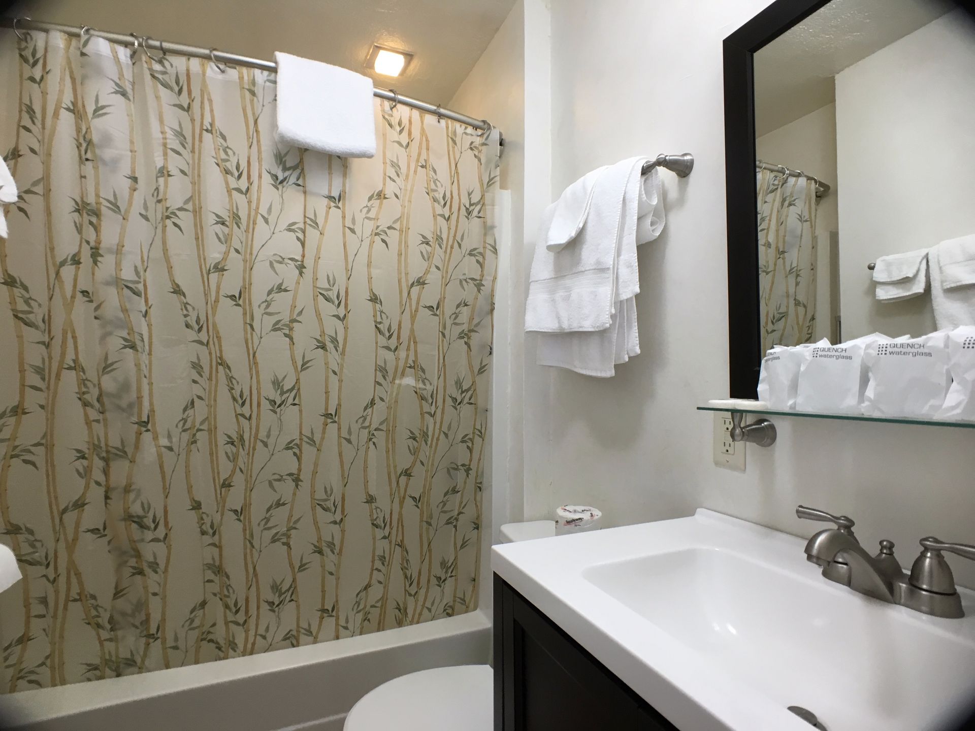 A bathroom with a sink , toilet , shower and mirror